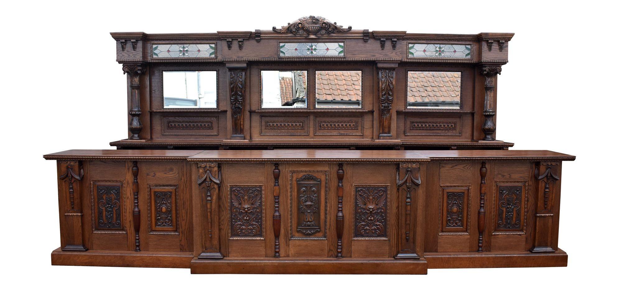 For sale is a good quality 15ft Victorian style carved oak front and back bar. Having a stepped and flared cornice, with a carved floral pediment to the centre, over panels of leaded glass, with bevelled mirrors below, the back counter has a single