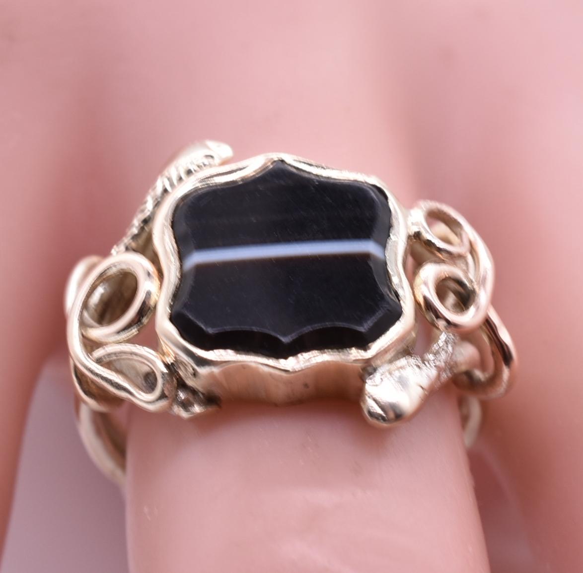 Wonderful unisex 15K snake signet ring with a Scottish banded agate stone at center. A snake surreptitiously weaves its way around each side of the charcoal colored banded agate at center. This ring is 15kbut has silvery tones. The ring works well