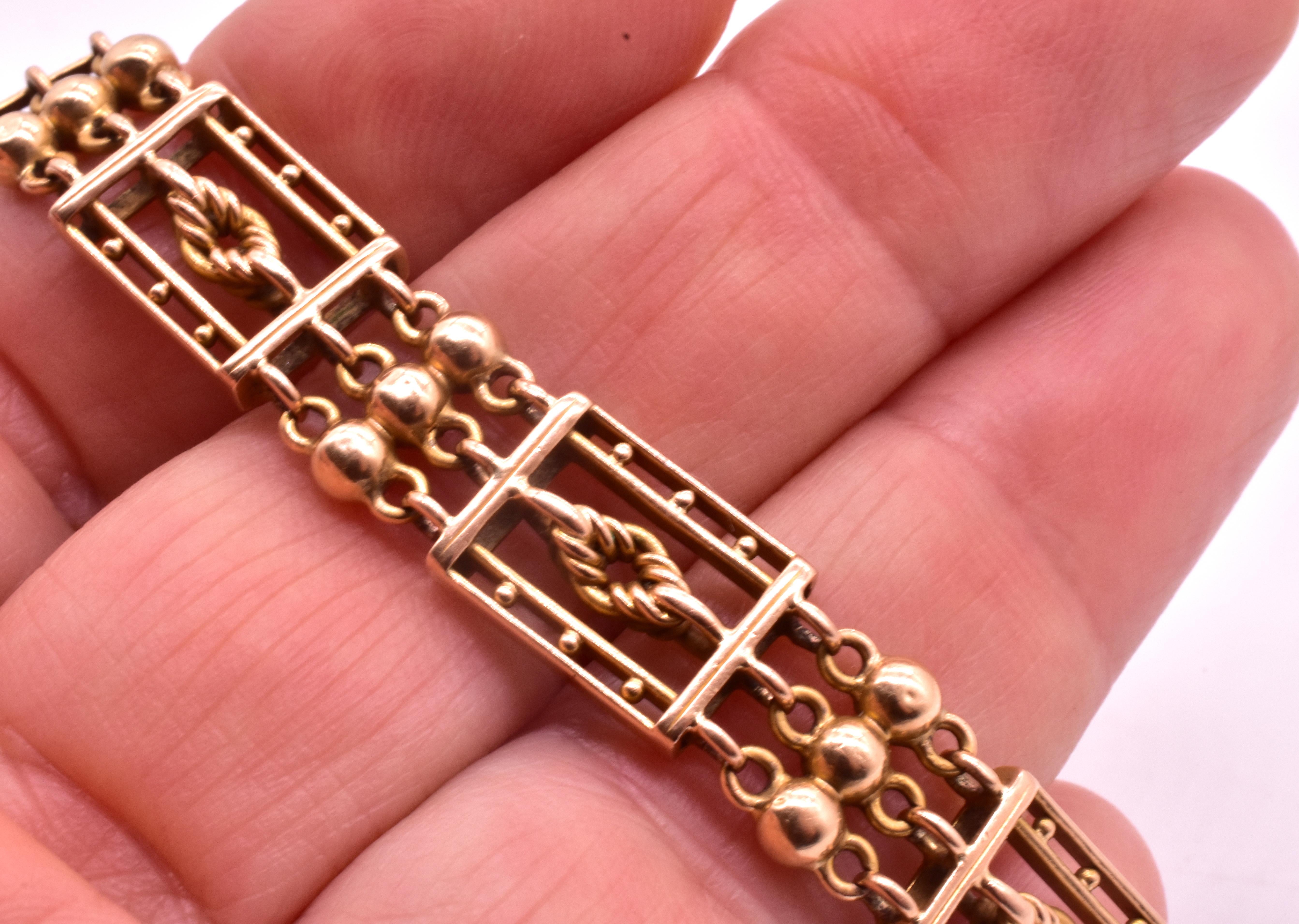Charming circa 1930 15K geometric gold bracelet with lover's knot links inside rectangles bordered with gold balls as one set of links, and a triplicate of gold balls comprising the next link. The pattern continues all around. This casual, classic