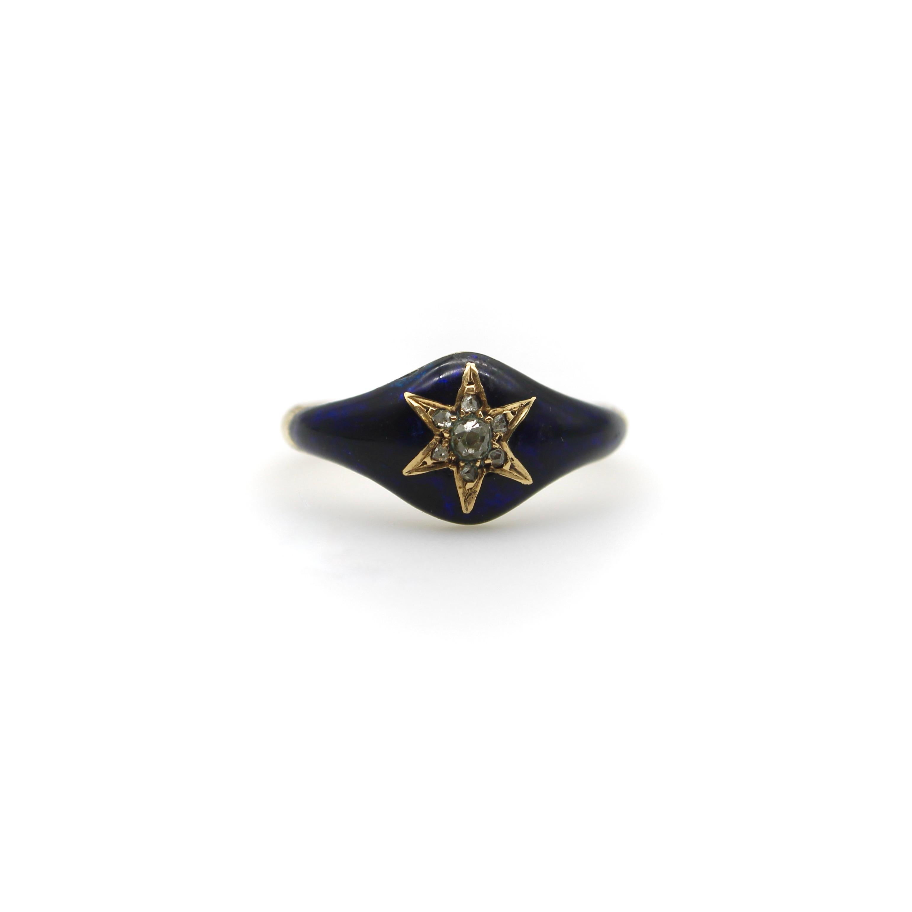 This 15k gold early Victorian ring features a diamond encrusted star surrounded by navy blue enamel. Seven diamonds are bead set into a beautifully carved out star that is the focal point of the ring. The center diamond is an oblong shaped Old Mine