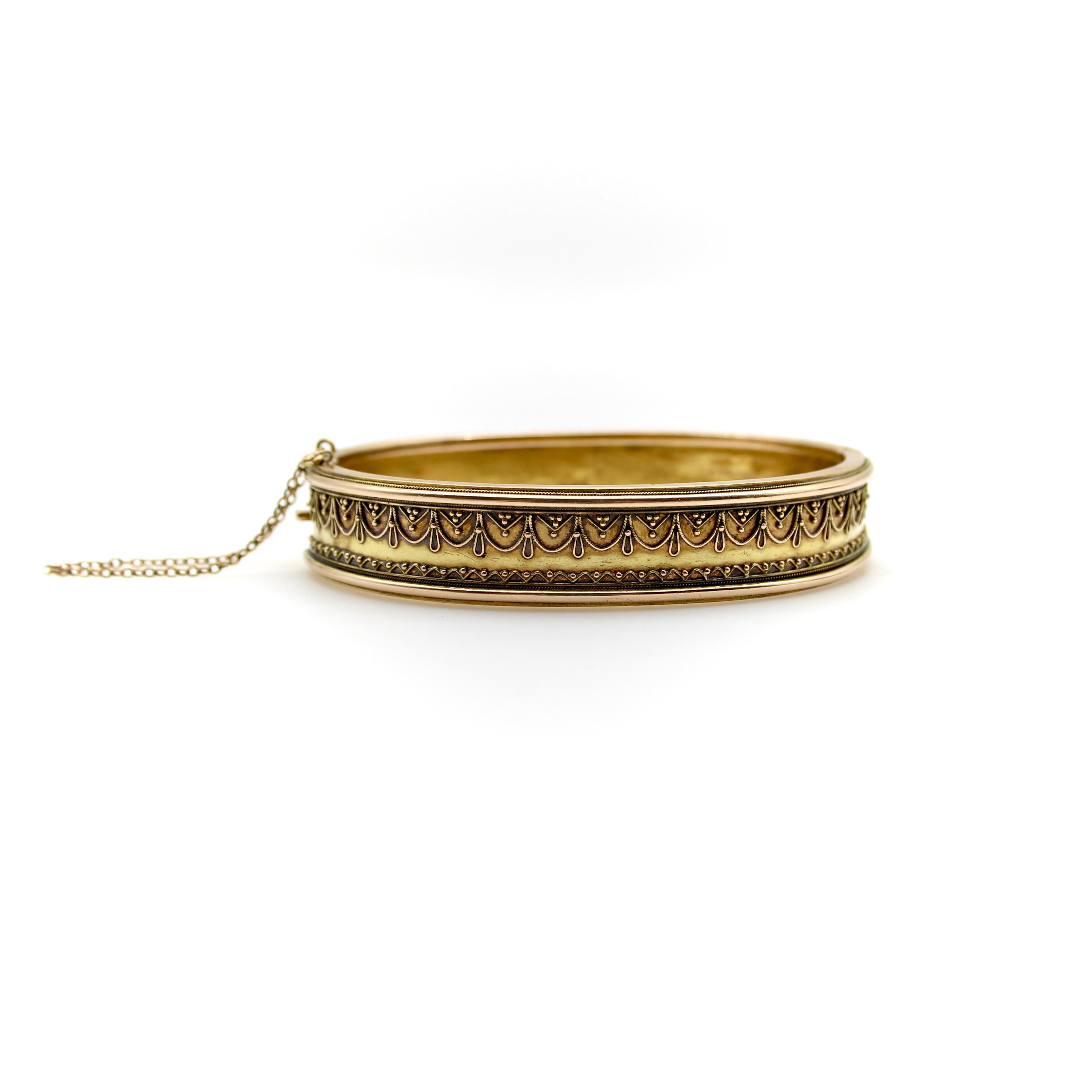This 15k gold Etruscan Revival Bracelet has delicate cannetille work done by hand. The twisted wire and granulation create a lacy pattern of swooping rope—opposite a zigzag pattern—dotted with tiny granulated balls for an added level of intricacy.