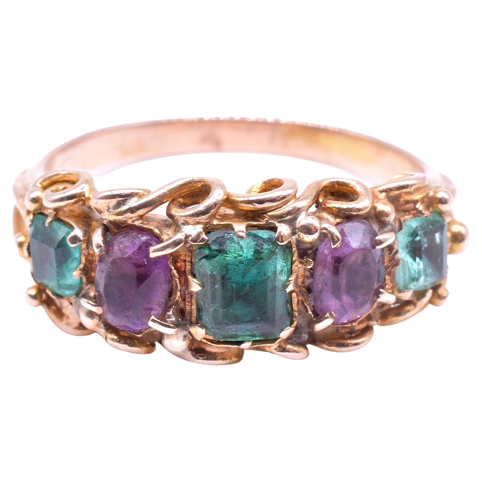 A colorful late 19th to early 20th Century Gold ring set with three large old mine cut Emeralds and two amethyst gemstones. This 5 stone gemstone ring is a classic late Victorian, early Edwardian design popular in the late 19th and early 20th