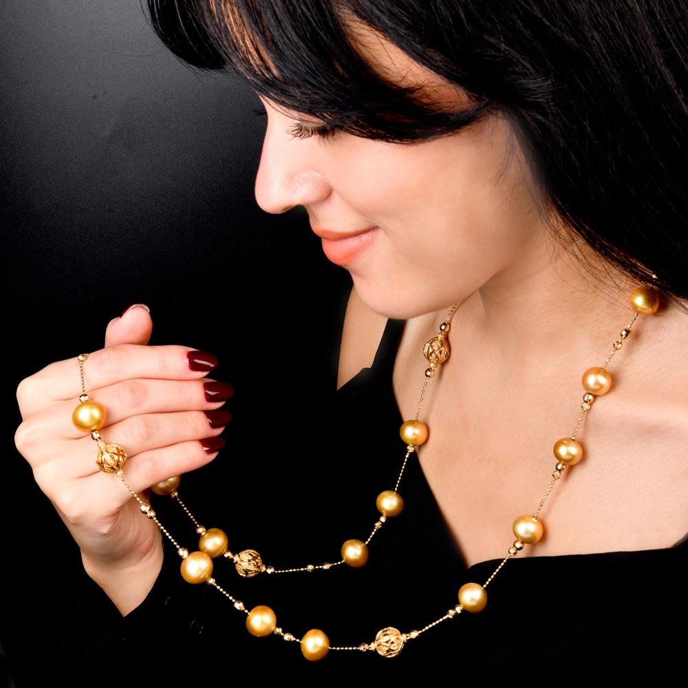 Featuring 15mm pearls of warm golden hue, the necklace is accented with intricate, floral-patterned gold round spacers and shimmering gold bead details.

Wear it long for a dramatic look or double it for a layered style. Its luminous pearls and rich