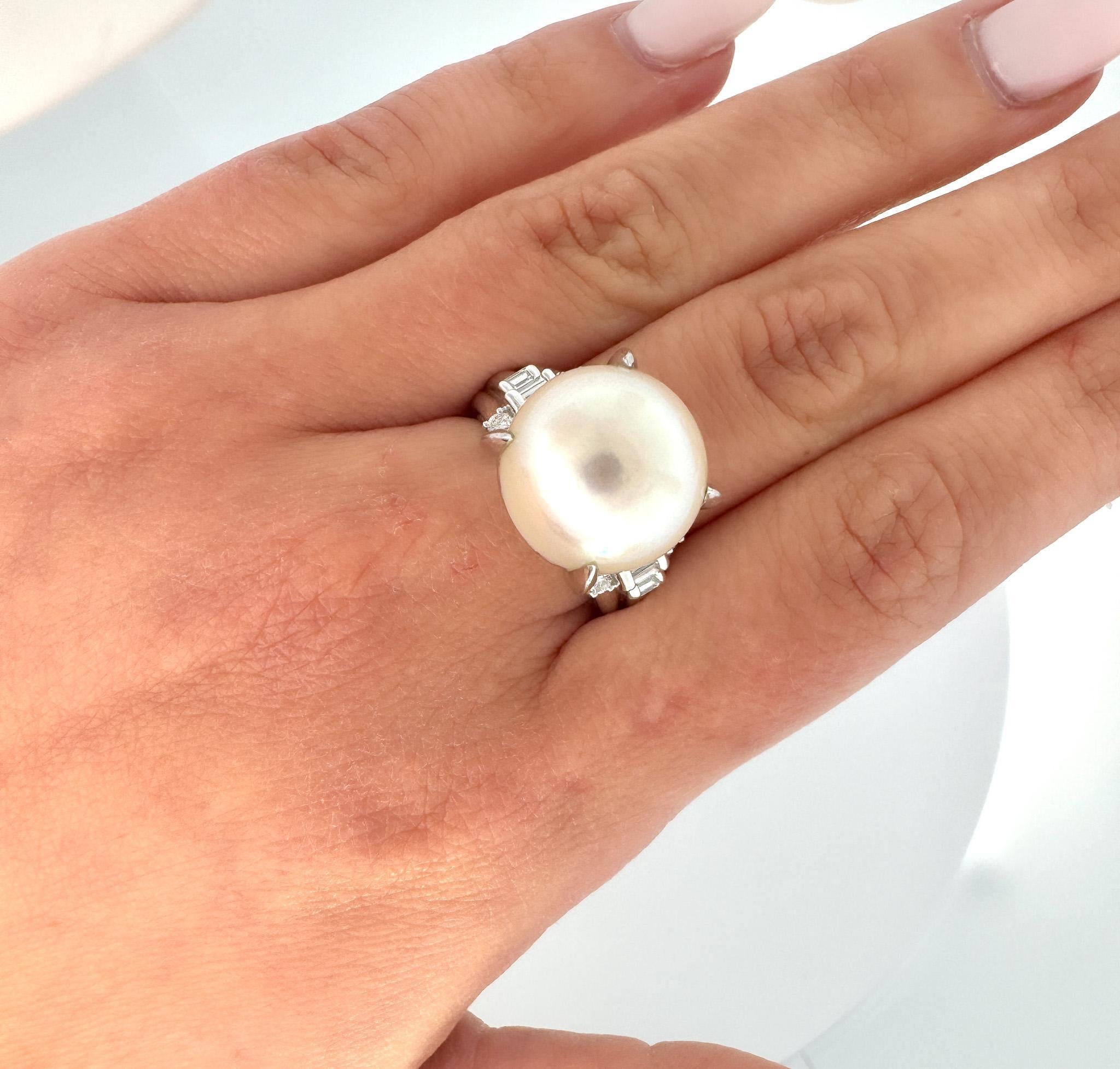 15mm South Sea Pearl and Diamond Platinum 900 Cocktail Ring. 

Featuring a lustrous 15mm south sea white pearl center stone, secured in a prong setting. The pearl is paired with 4 round cut and 4 baguette cut natural diamonds. The pearl is  secured
