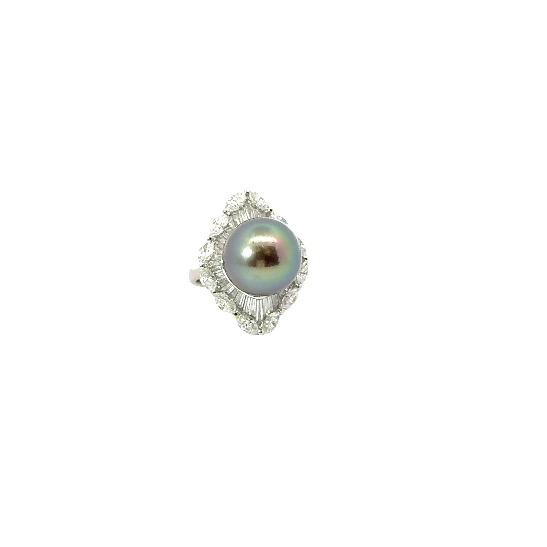 Un sorprendente anello da cocktail con una perla tahitiana di 15 mm. La tonalità profonda e lucente della perla è il fulcro di questo disegno e ha una ricca sfumatura di pavone, con riflessi di verde e rosa che attraversano la perla. È circondato da