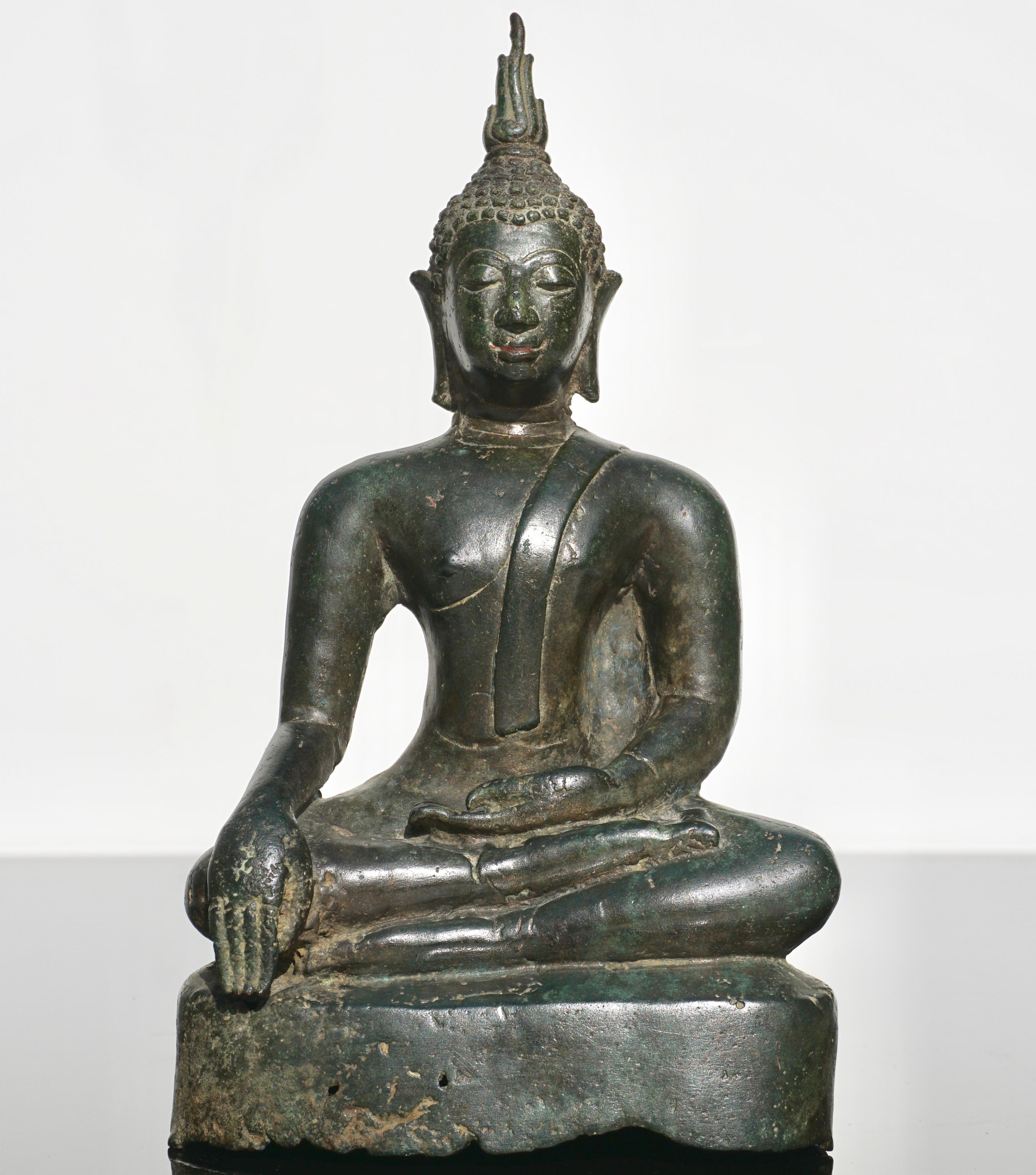A bronze seated figure of Buddha Statue
Thailand, Ayutthaya period, 15th-16th century (early Ming dynasty period)

The face with elongated eyes beneath arched brows, flanked by pendulous earlobes, the hair in tight curls and the ushnisha topped by a
