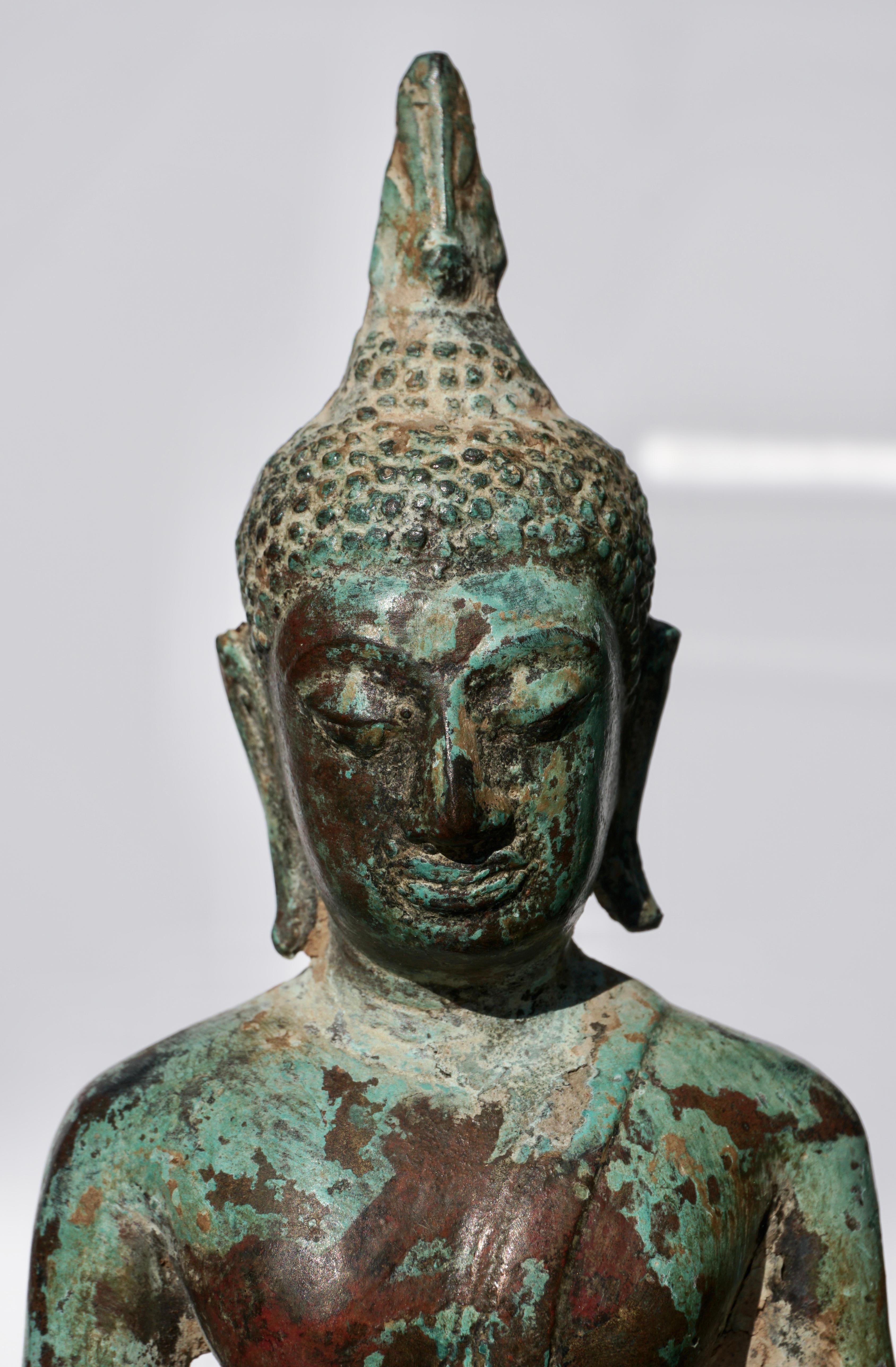 A bronze seated figure of Buddha Statue Thailand, Ayutthaya period, 15th-16th century (early Ming dynasty period) The face with elongated eyes beneath arched brows, flanked by pendulous earlobes, the hair in tight curls and the ushnisha topped by a