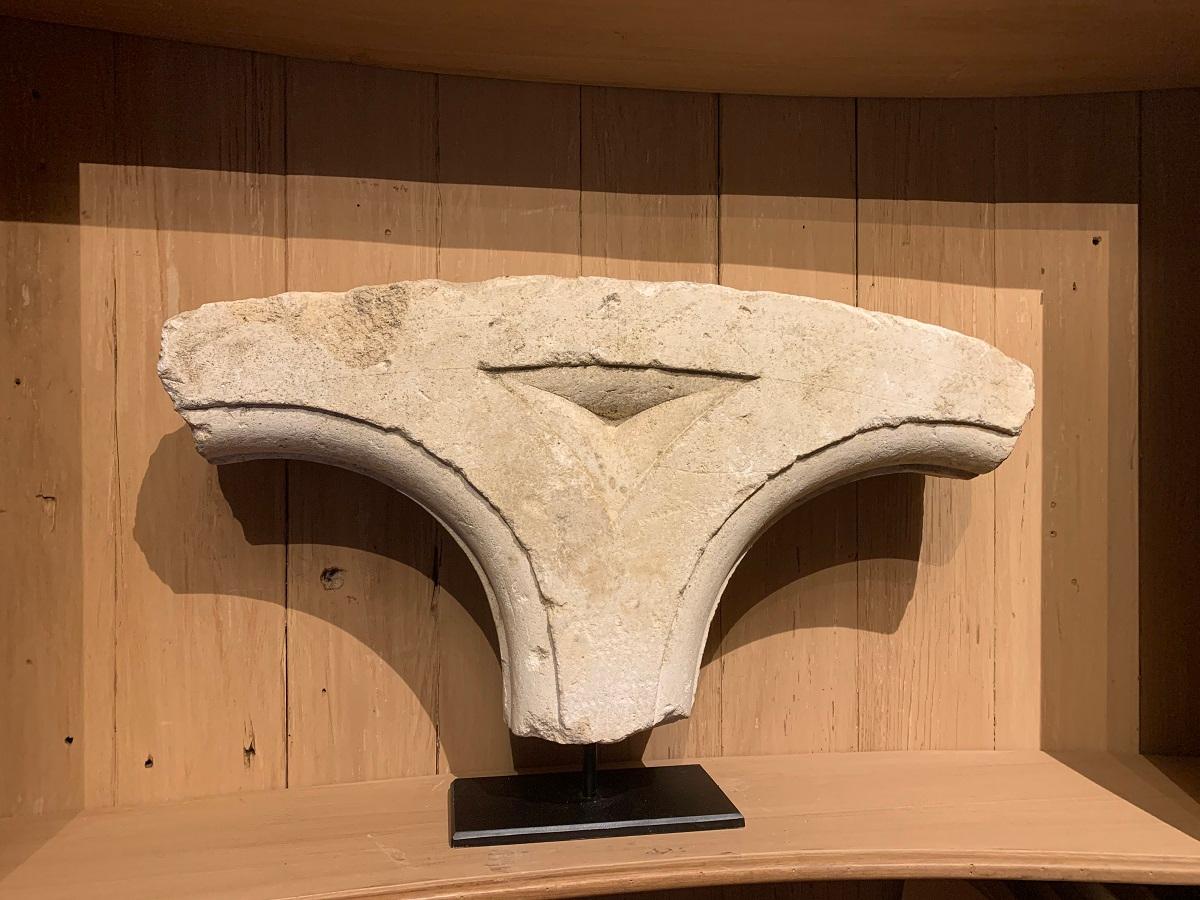 A French sandstone architectural fragment. Dating from the Gothic period this keystone probably supported bowed arches or domes placed upon a column. The sobre geometrical design accentuating the curves of the arches.
This fragment is in fine