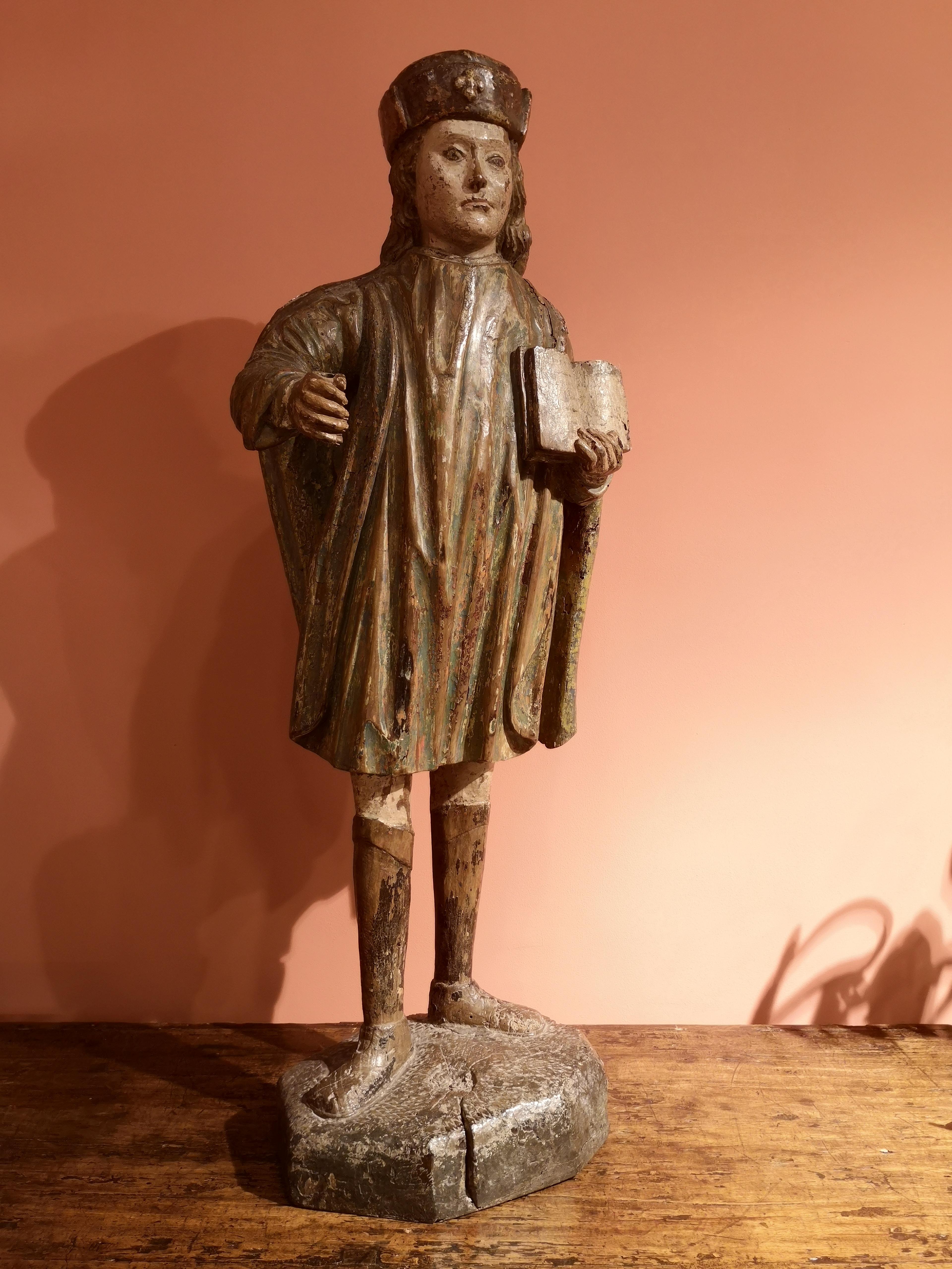 This sculpture depicts Saint James the Major. He is dressed in a green tunic and covered with his capelet. He’s wearing a pair of boots. He has a fine nose and pinched lips. and a delicately wavy hair. His head is covered with a small square cap