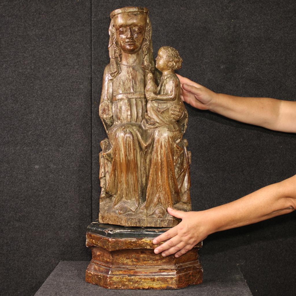 A rare 15th-century religious sculpture. A finely carved wood work depicting the Madonna with Child, likely of Central European origin. Carved from a single block, with a separate, non-contemporary base, the Virgin is seated on a throne with the
