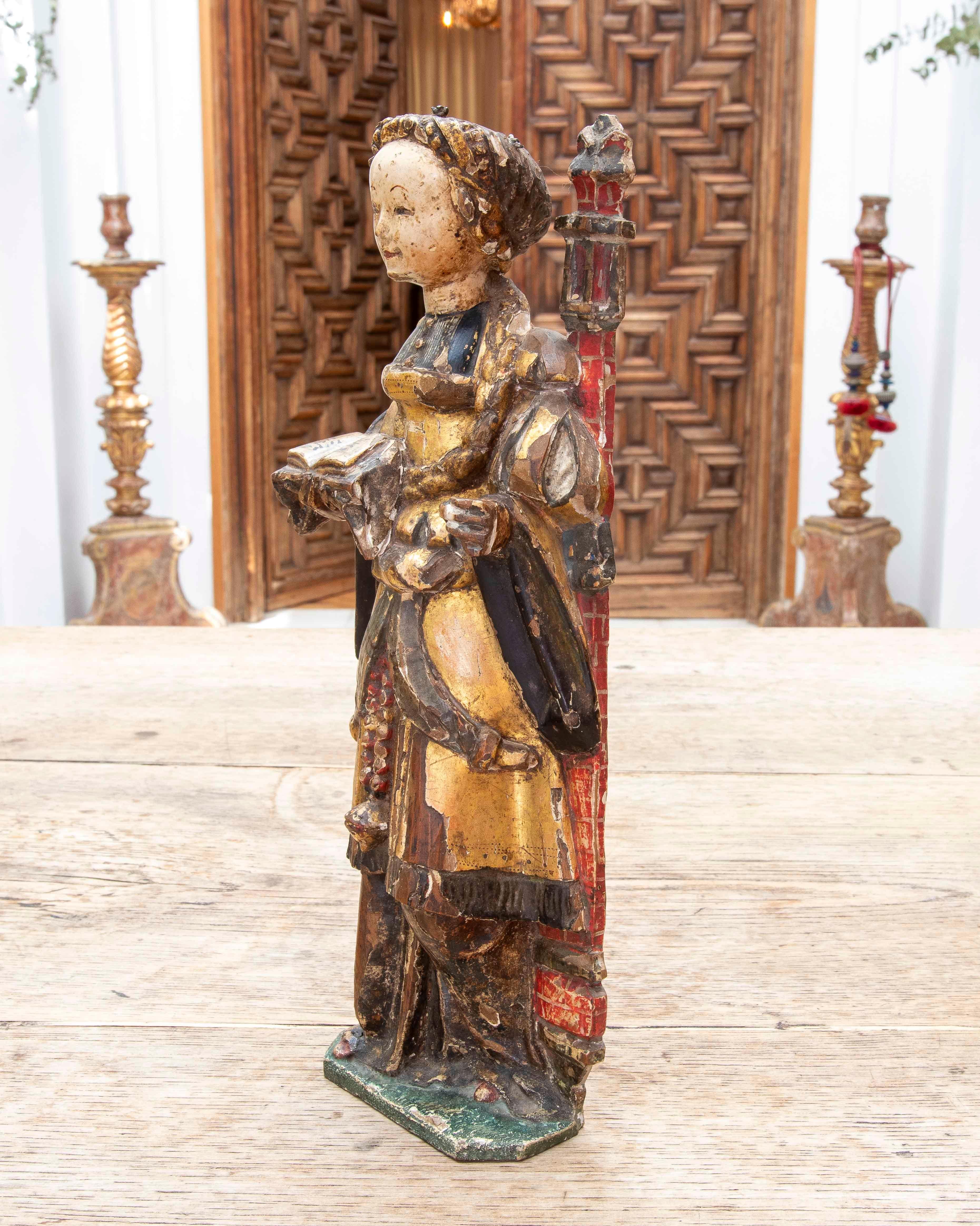 Diese Skulptur stellt das Mädchen von Nicomedia dar, das in einem Turm mit drei Fenstern gefangen gehalten wird, wo ihr Vater sie einsperrt. In der rechten Hand hält sie ein aufgeschlagenes Buch, in dem ihre Meditationen während der Gefangenschaft