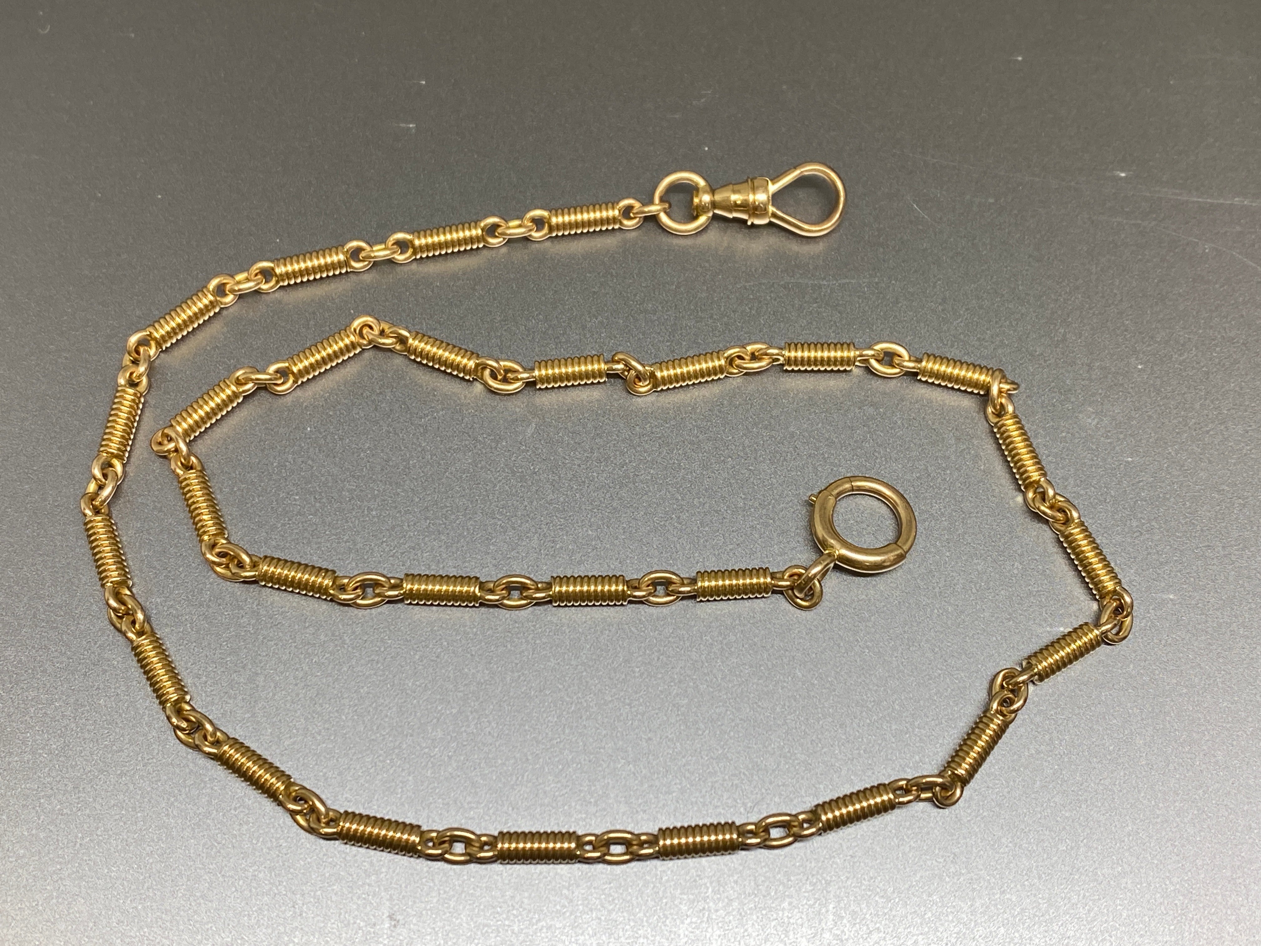 This late 19th century fancy link watch chain has been crafted in solid 14k gold.  It is a stunning warm rosy-yellow gold and consists of special, unusual fancy links that look like tightly coiled spiral springs. The watch chain is fitted on one end