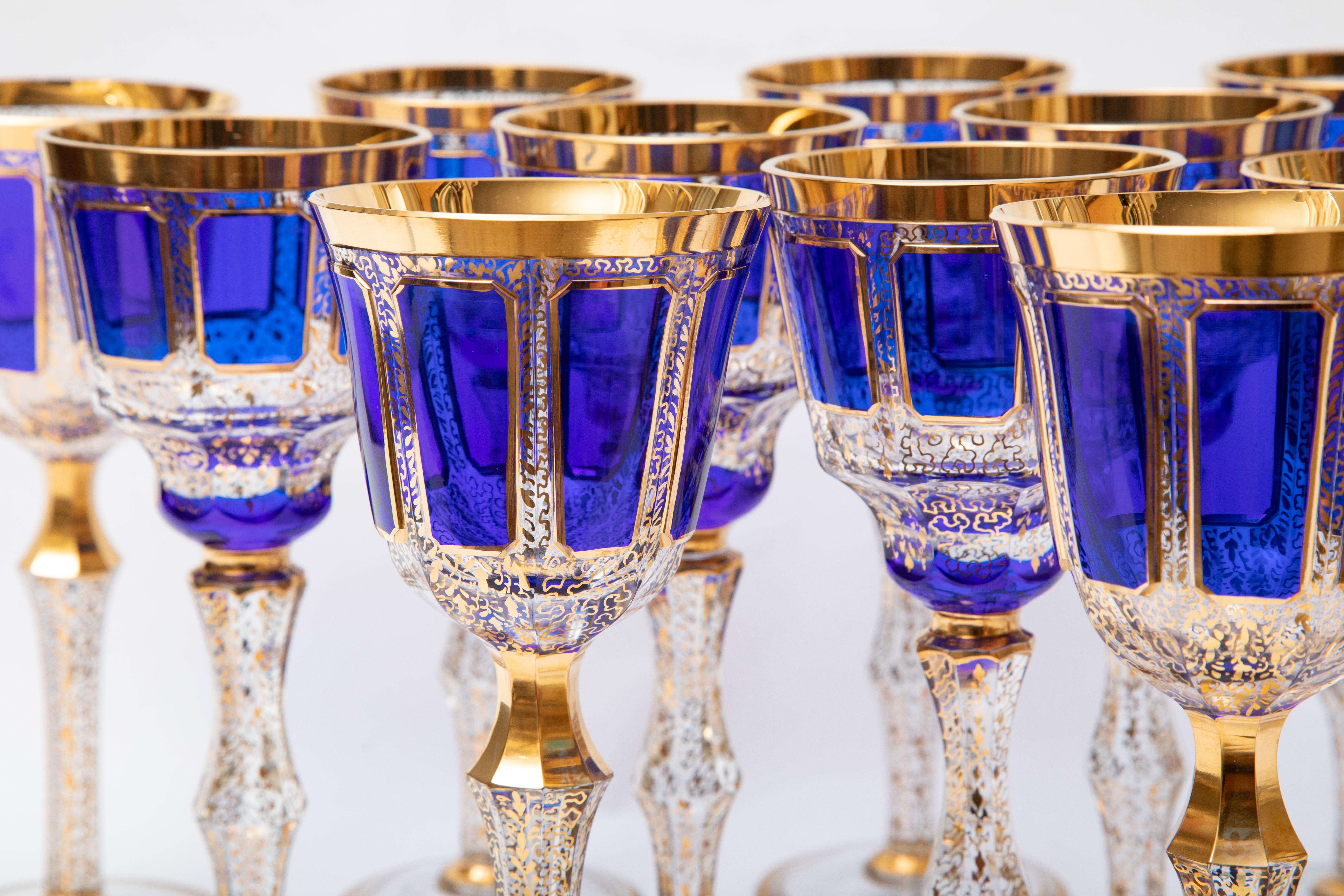 A coordinating set of tall elegant goblets from the 1920's. We attribute them to the prolific firm of Moser. They feature elongated cabochon panel styling with alternating cobalt blue color. The gilt work is very detailed in a modified scroll