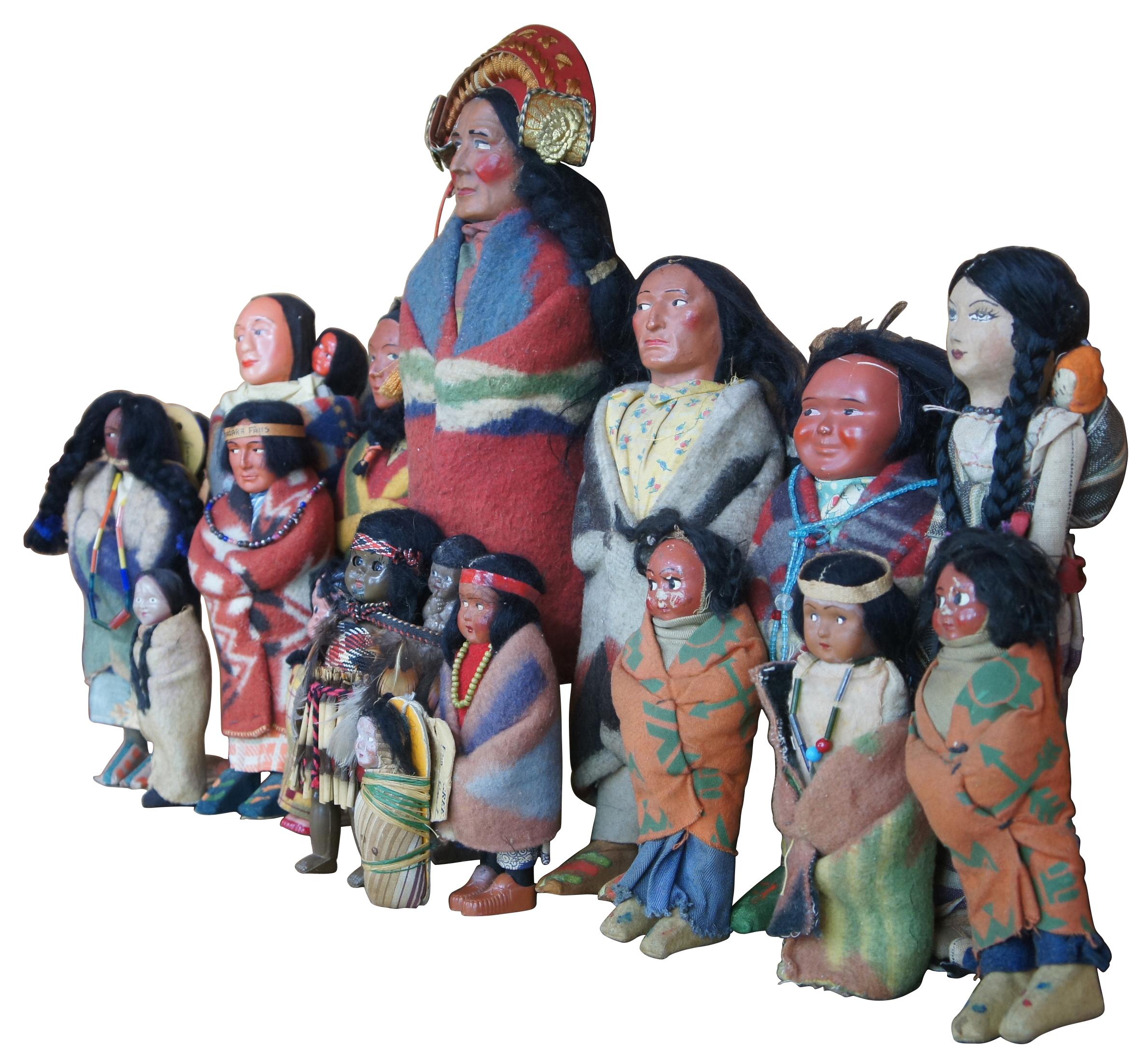 Lot of 16 antique Native American Skookum dolls featuring men, women, children and babies wearing traditional wool clothing with beaded accents, headdresses and tapestry blankets.

largest- 5