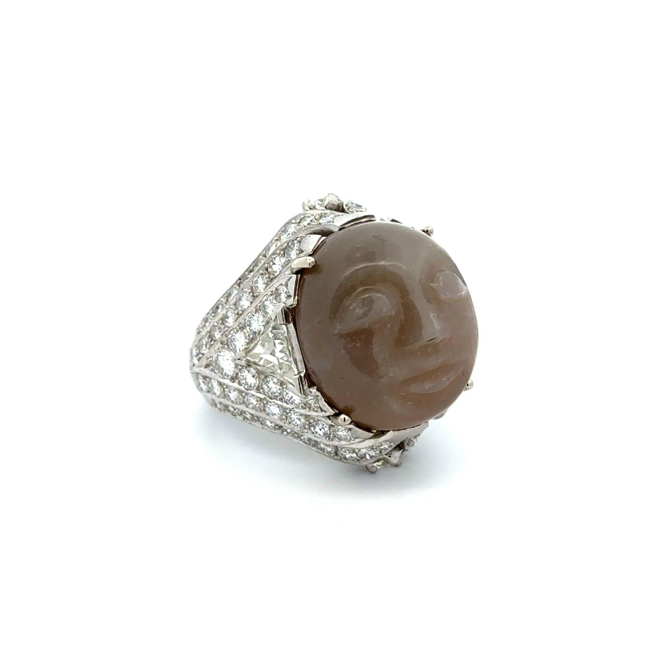 Simply Beautiful! Finely detailed Vintage Carved Moonstone and Diamond Ring. Featuring a Hand set securely nestled 16 Carat Carved Moonstone. Enhanced with Trillion and Round Brilliant Cut Diamonds, weighing approx. 4.00tcw. Hand crafted Platinum