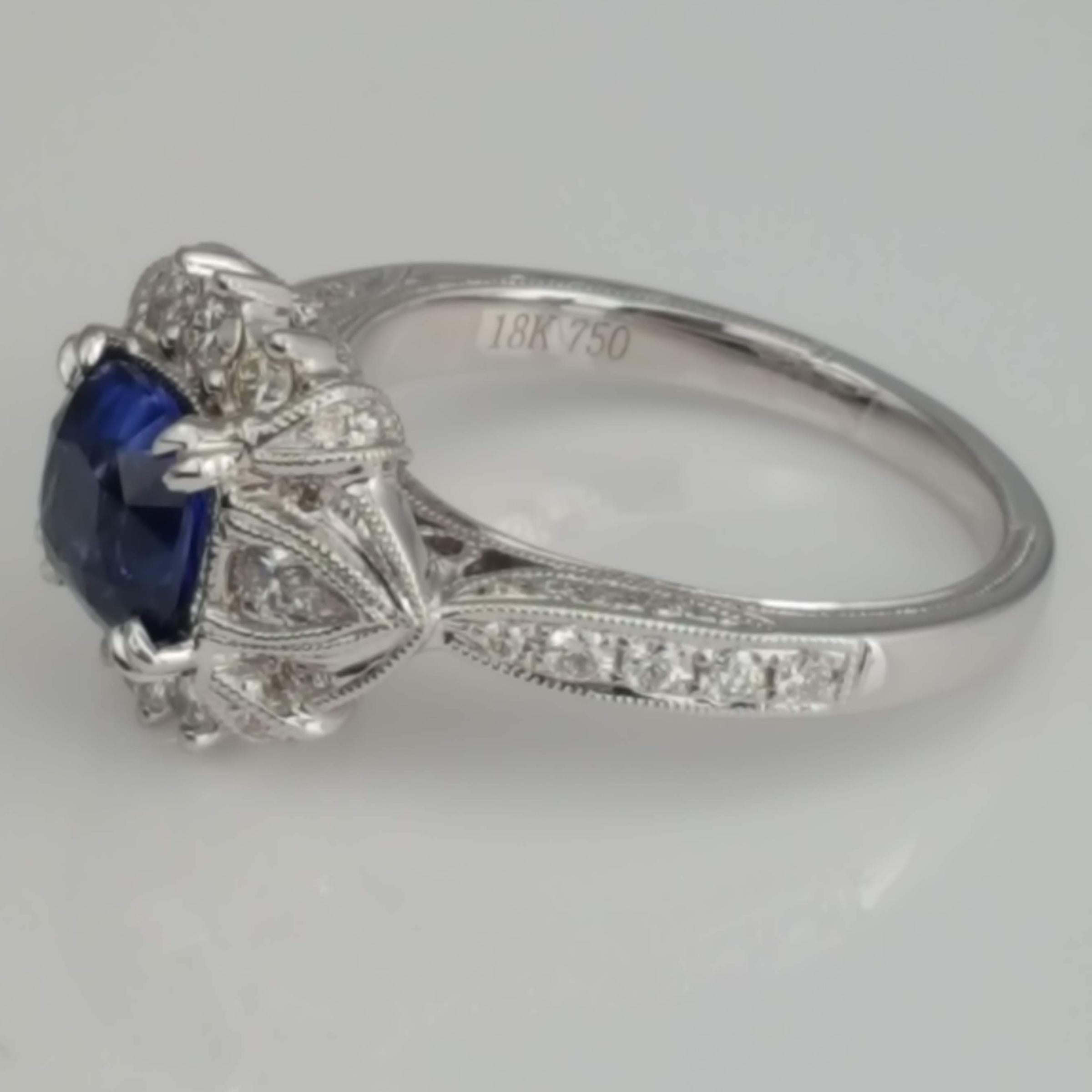 Dieser wunderschöne Ring enthält einen blauen Saphir mit 1,60 Karat im Kissenschliff, der von 0,63 Karat birnenförmigen und runden Diamanten umgeben ist. Die handgravierte Maserung und die Designelemente der alten Welt verleihen diesem Schmuckstück