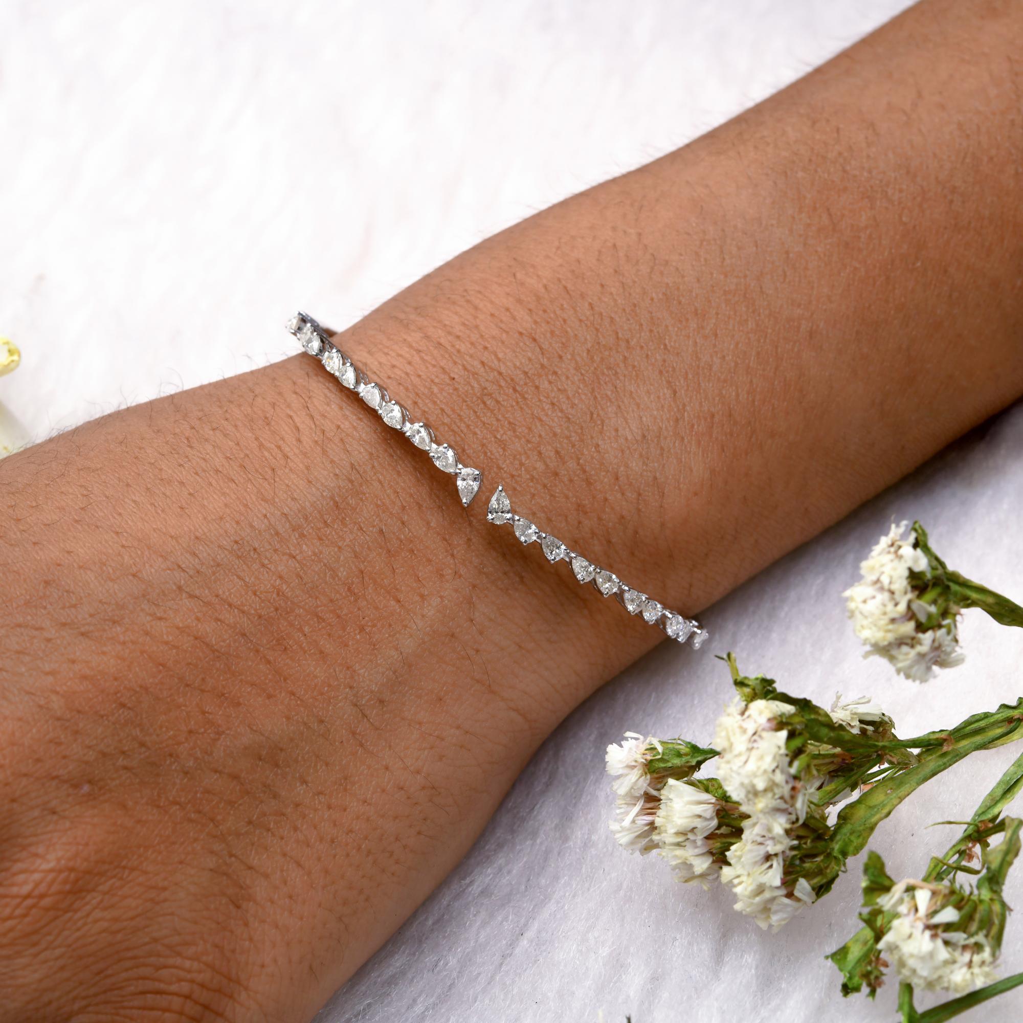 Questo bracciale da polso in oro bianco 18 carati con diamanti a pera da 1,6 carati SI Clarity HI Color è caratterizzato da diamanti a taglio pera incastonati nella metà anteriore del bracciale bangle aperto. 
I diamanti sono un simbolo universale