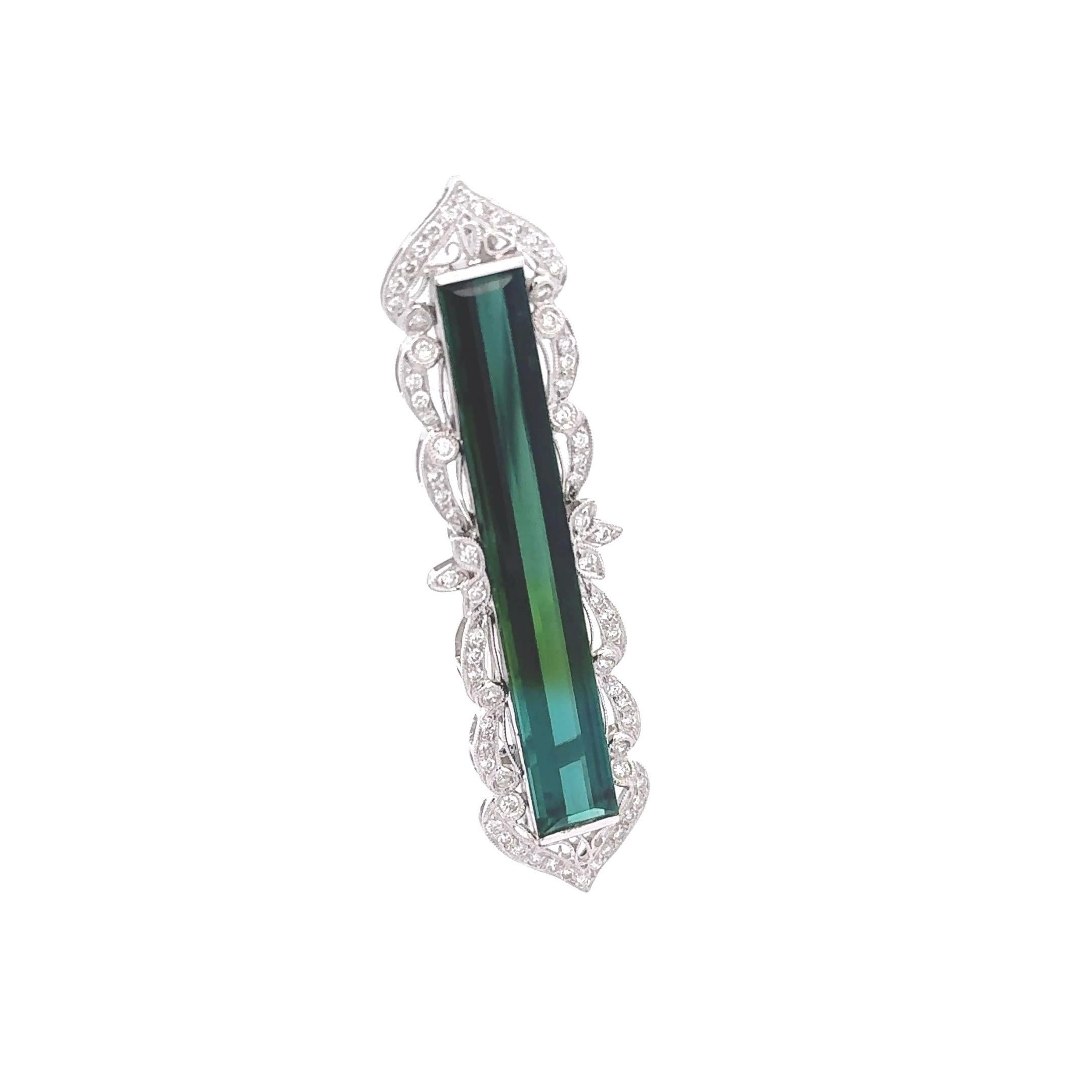 A modern brooch featuring a striking 16.0-carat long baguette-cut green tourmaline. The vibrant blue-green hue of the tourmaline is accentuated by 0.72 carats of round white diamonds, adding a touch of brilliance. Crafted in 18k white gold, the