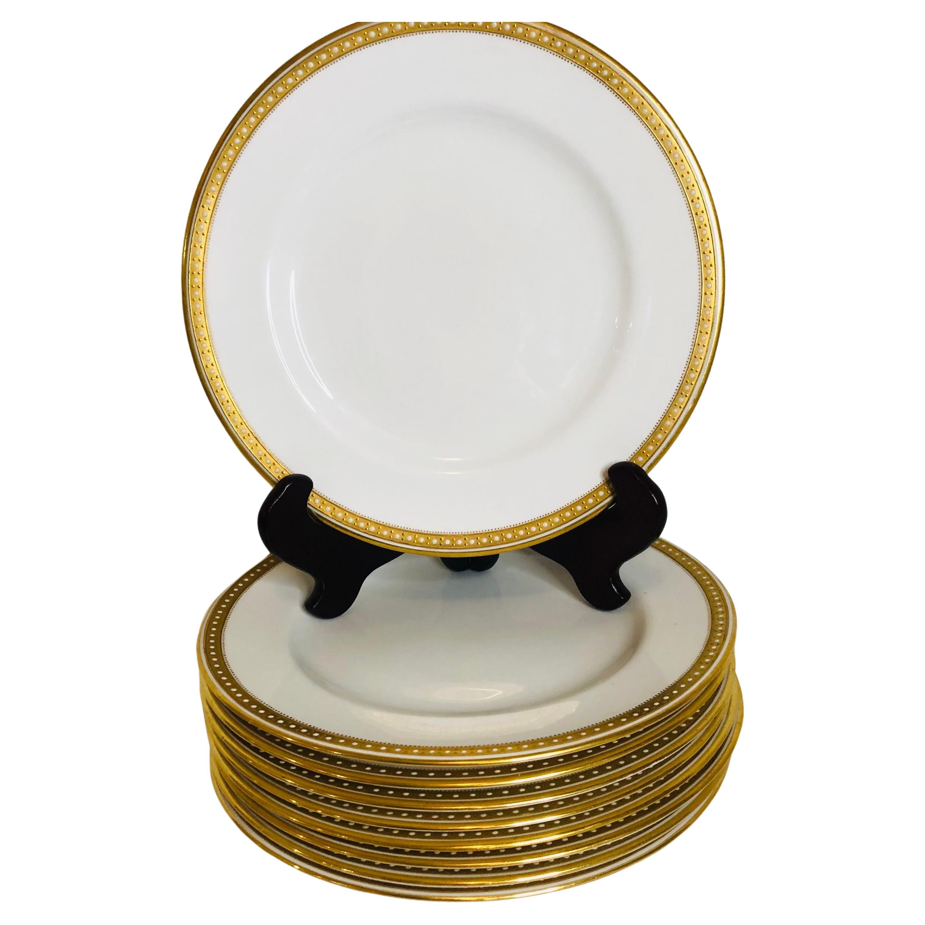 I am offering you this exquisite set of sixteen Copeland Spode dinner plates which have a gold border and white enamel jeweling on a white porcelain body. They definitely look like simple elegance, and they would look beautiful with any dinnerware