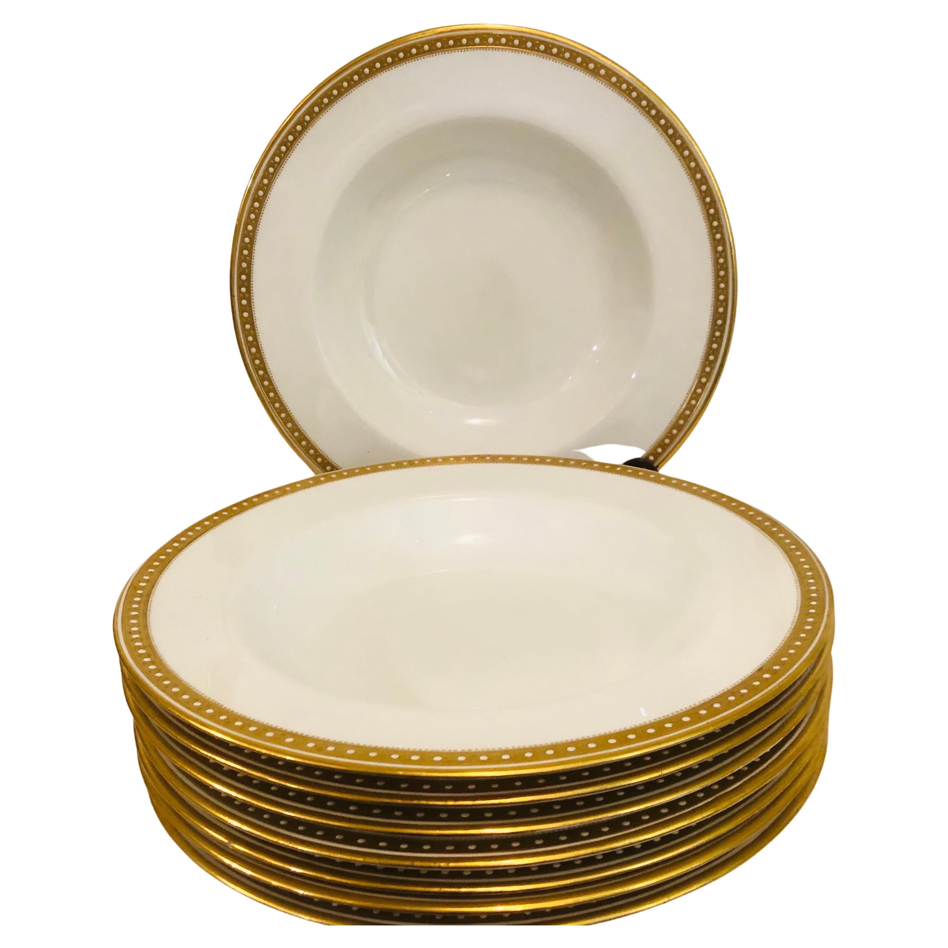 I am offering you this exquisite set of sixteen Copeland Spode deep wide rim soup bowls, which each have a gold border with white enamel jeweling on a white porcelain background. They definitely look like simple elegance, and they would look