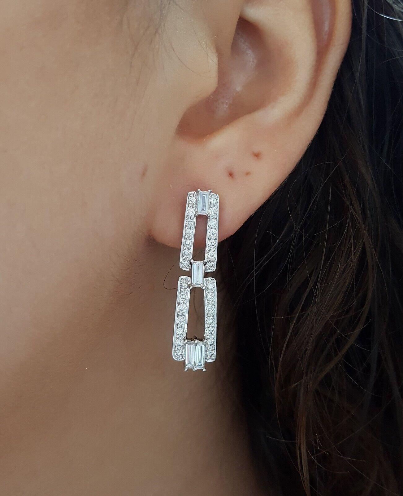 Pendientes colgantes de diamantes redondos y talla baguette de 1,6 ct y oro blanco de 18k.
Los pendientes pesan 6,9 gramos, contienen 56 diamantes talla redonda y 8 talla baguette con un peso aproximado de 1,6 ct, los diamantes son de color E-G,