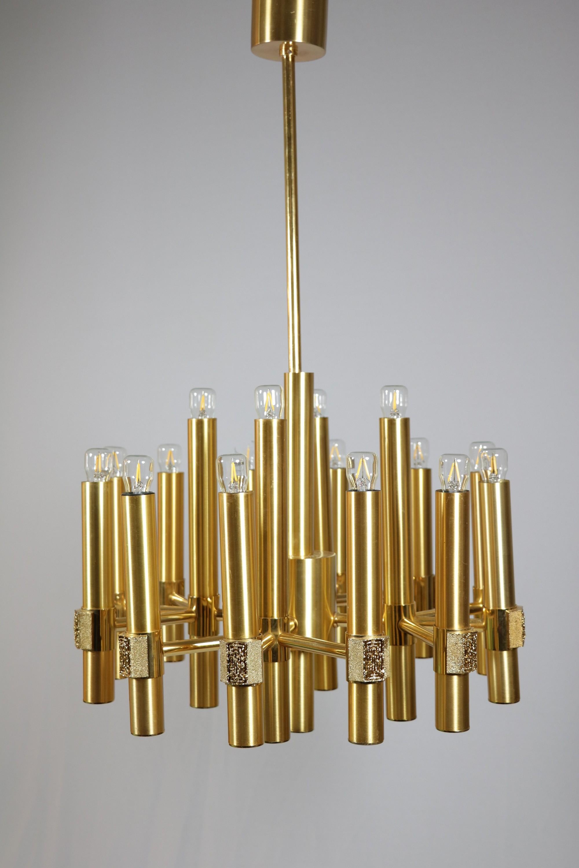 Representative chandelier made of brass.
By ESPERIA, Italy.
Designer: Angelo Brotto.
 
Very high quality workmanship, with brutalistic elements on the socket sleeves.
Makes a luxurious impression, and yet is restrained.
 
Measures: Diameter: