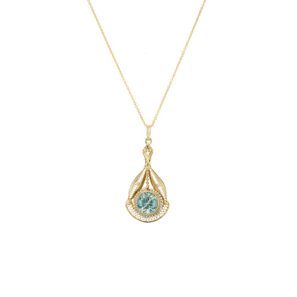 Early 1900's Zircon and pearl pendant necklace. 1.60ct round blue zircon set in a 14k yellow gold pendant setting accented with 31 natural white seed pearls. 14k yellow gold 16 inch chain.

1 round blue zircon, approx. 1.60cts
31 natural white seed
