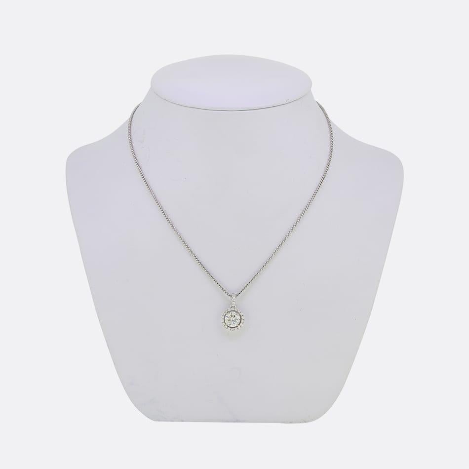 Se trata de un colgante con halo de diamantes de oro blanco de 18 ct. El colgante lleva un diamante central redondo de talla brillante engastado en un halo y suspendido de una cadena de oro blanco de 9 ct.

Estado: Usado (Muy bueno)
Peso total: 6.8