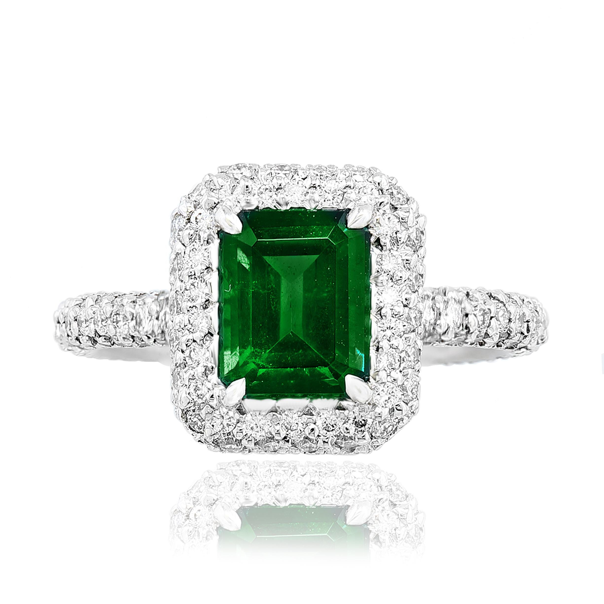 Showcasing a 1.60-carat emerald cut emerald set in a polished platinum mounting accented with diamonds. Accent diamonds are set in a micro pave setting all around the center stone and halfway on the side weighing 11.49 carats total.  Size 6.5 US