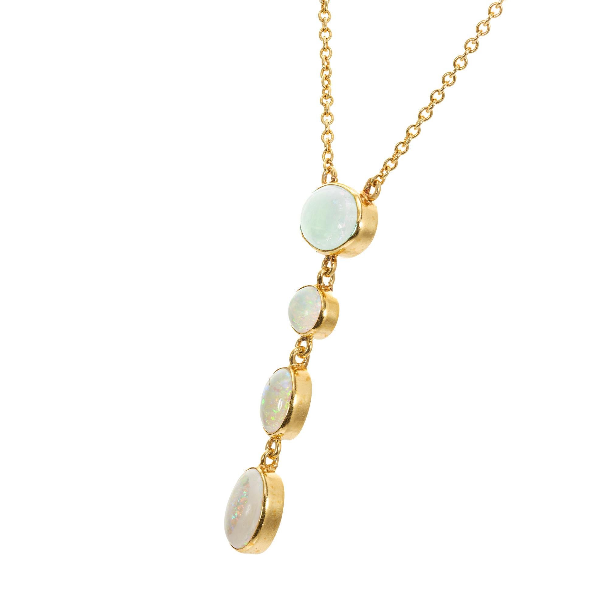 Australian opal necklace pendant. 4 natural round a and oval untreated blue green opals in a handmade dangle bezel set drop pendant in 14k yellow gold. 19 inches in length.  Circa 1940's.

3 oval bluish green opals, approx. 1.35cts
1 round bluish