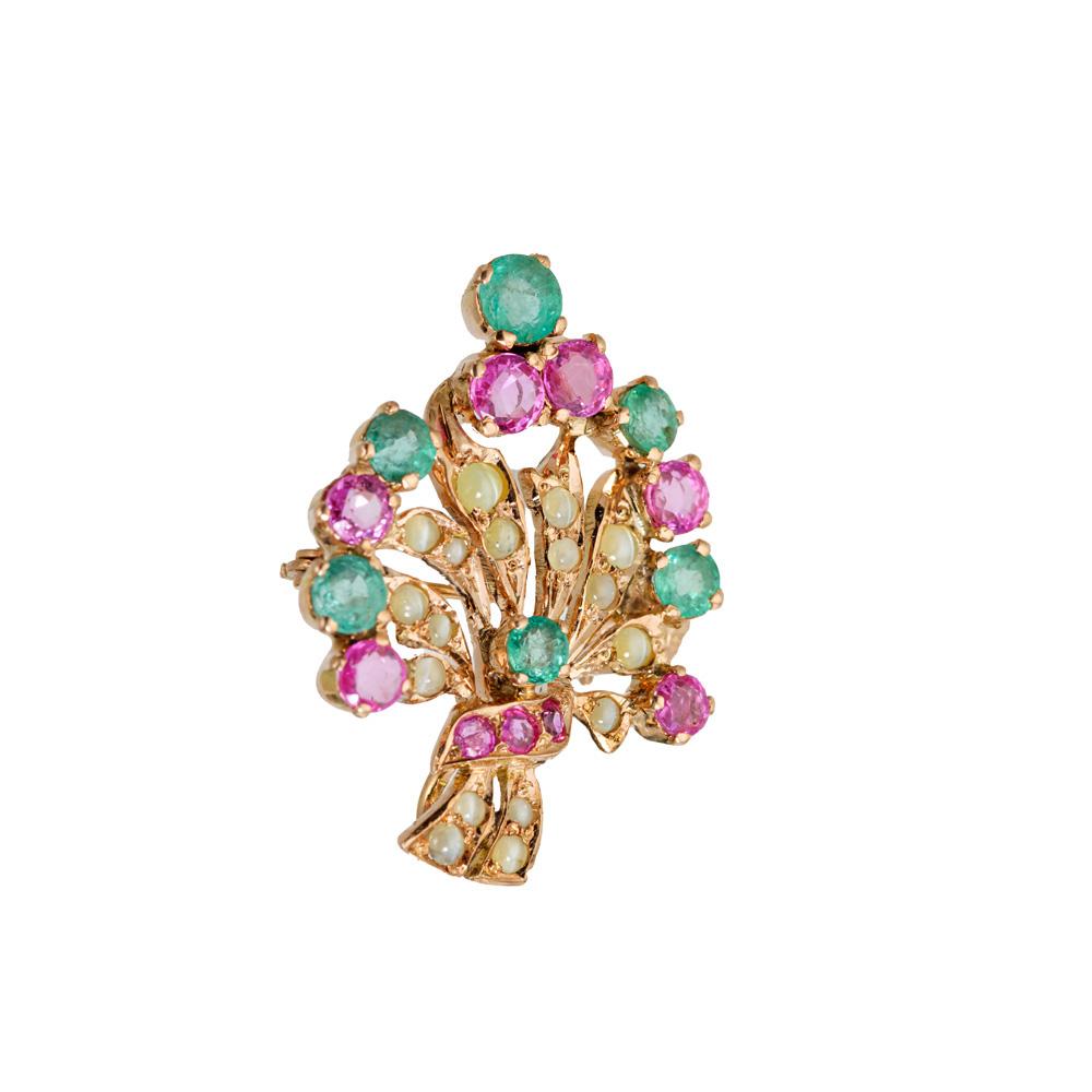 Flower gemstone brooch and pendant. This beautifully hand crafted 1940's brooch is enriched with 9 round red purplish round sapphires intermixed with 6 round green emeralds and accented with 17 yellowish cabochon chrysoberyl cats eye. The flower