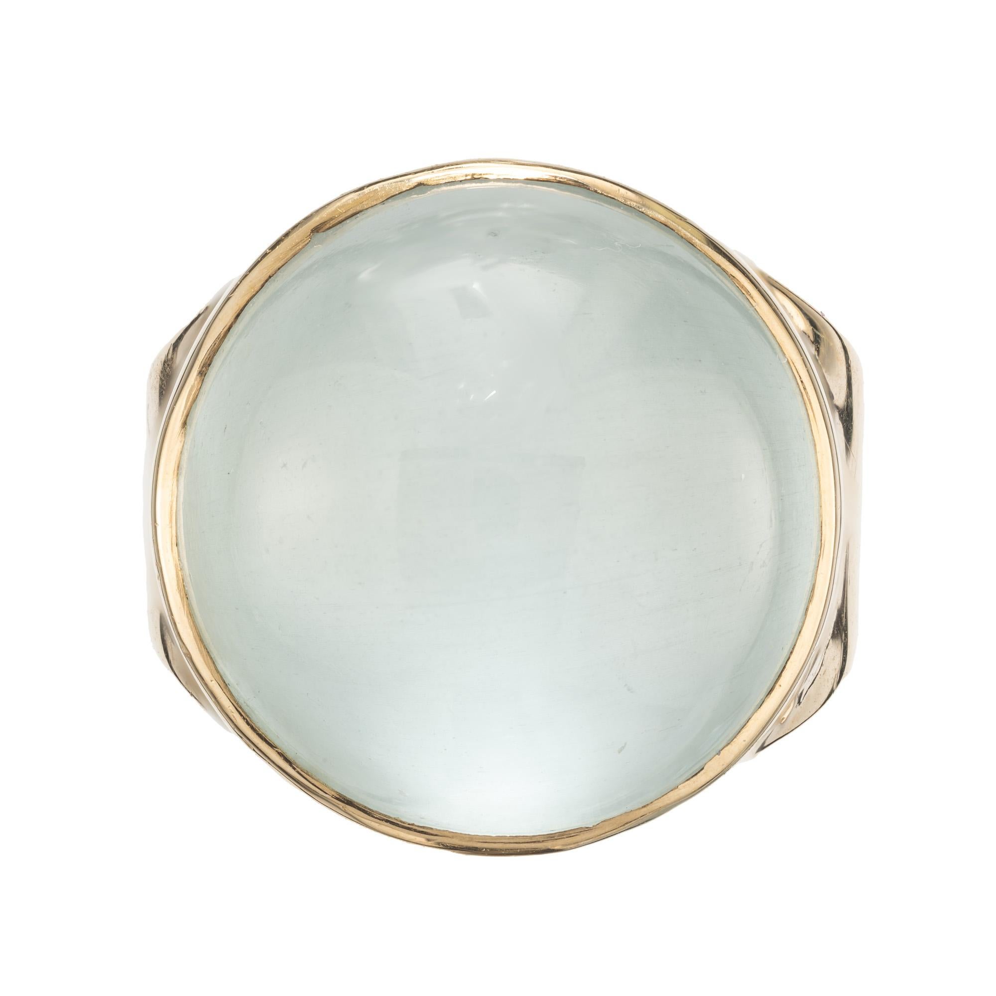 Beautiful highly translucent 16.00 carat cabochon aqua in a classic 1950's bezel set ring. The striking round cabochon aquamarine stone, with its mesmerizing blue hue reminiscent of the ocean, is set in a luxurious 14k yellow gold open work mounting