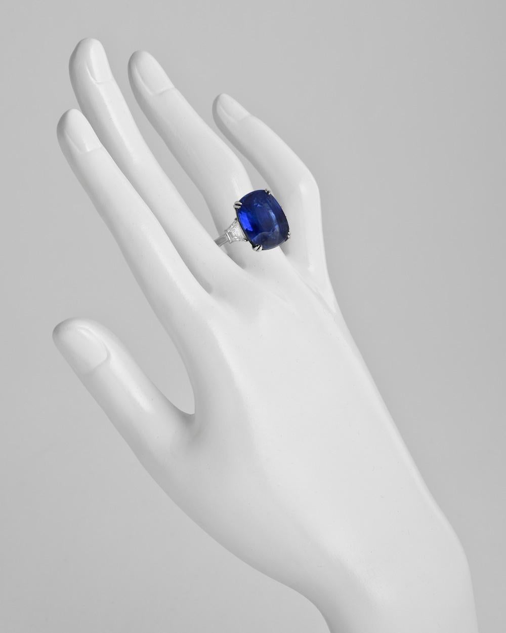 Ceylon sapphire and diamond ring, centering a natural no-heat cushion-shaped sapphire weighing 16.04 carats, flanked by a trapeze-cut diamond at either shoulder, the pair of diamonds weighing approximately 1.06 total carats, mounted in platinum.