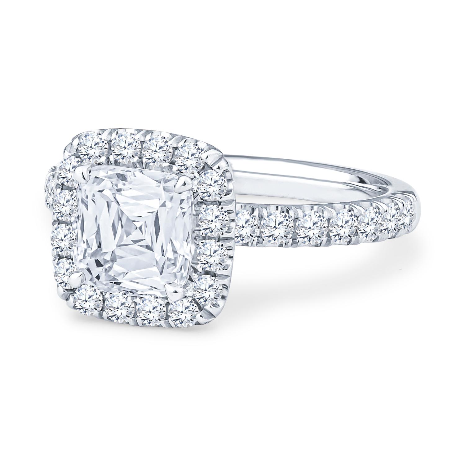 This 1.60ct natural Crisscut cushion diamond, J VS1, GIA #16315010 (inscribed CRISSCUT CU 1949) is set in an 18kt white gold cushion halo engagement ring. There are 30 round brilliant cut diamonds going halfway across the band that have a 0.45ct