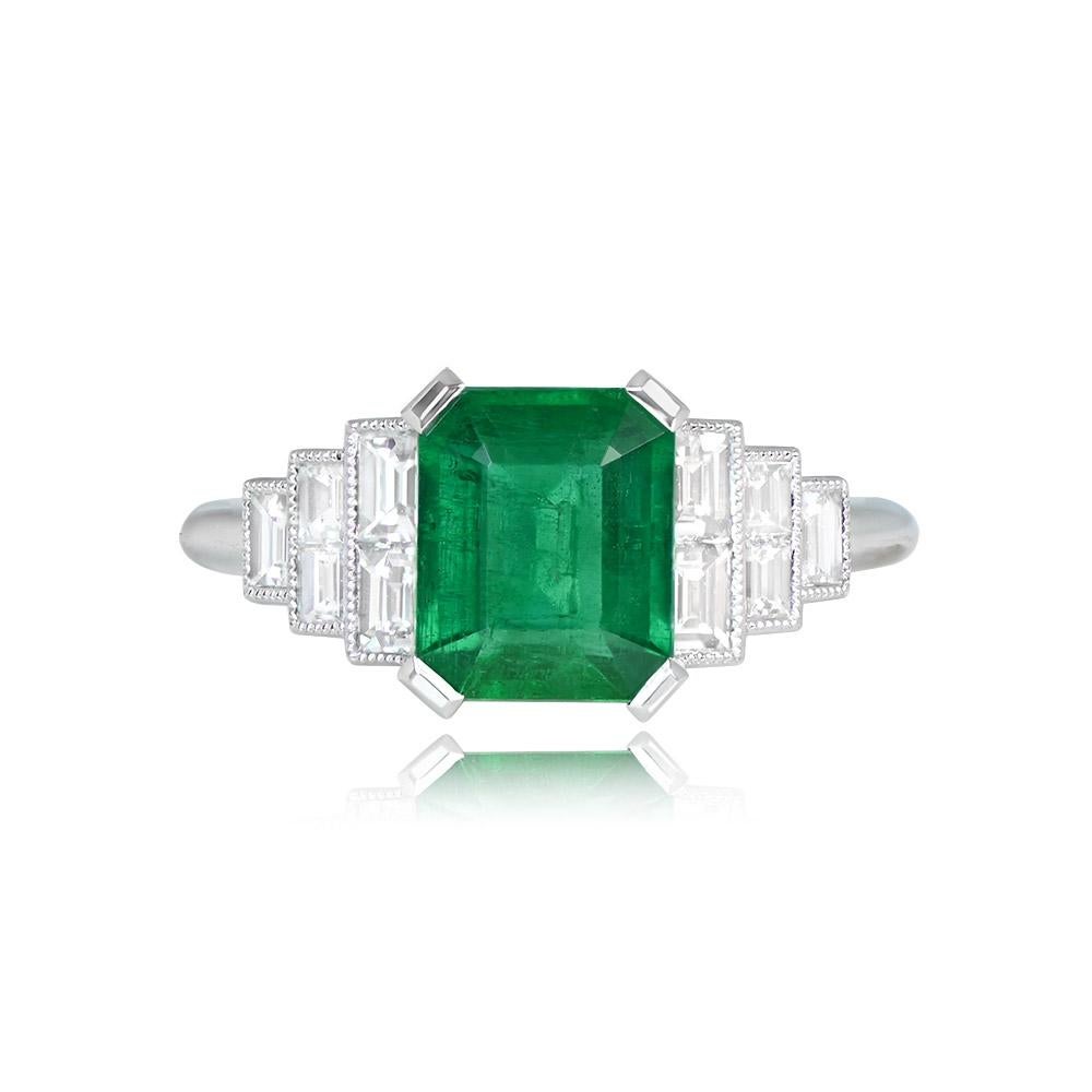 This platinum ring features a stunning emerald-cut 1.60-carat natural emerald, securely set with prongs. The center stone is beautifully complemented by five baguette-cut diamonds on each shoulder, arranged in a graduated design. The total diamond