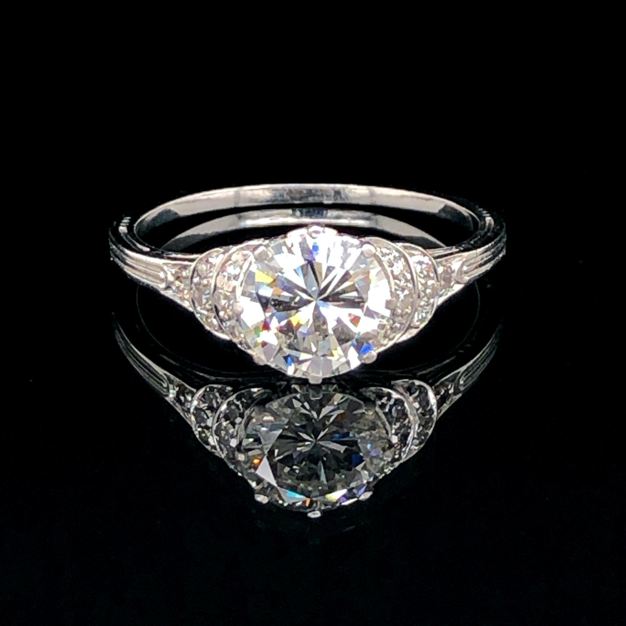 A beautiful Art Deco diamond solitaire ring in platinum, ca. 1920s. The centre diamond weighs approximately 1.60ct and is of G/H colour and VS clarity, accompanied by a HRD certificate. It is flanked by a curved step design set with single cut