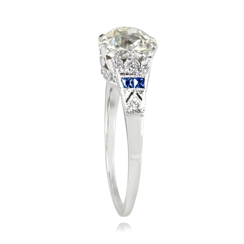 This engagement ring showcases a 1.60-carat old European cut diamond (J color, VS1 clarity) with geometric shoulders adorned by French cut sapphires and old European cut diamonds. The crown-style under-gallery also features old European cut