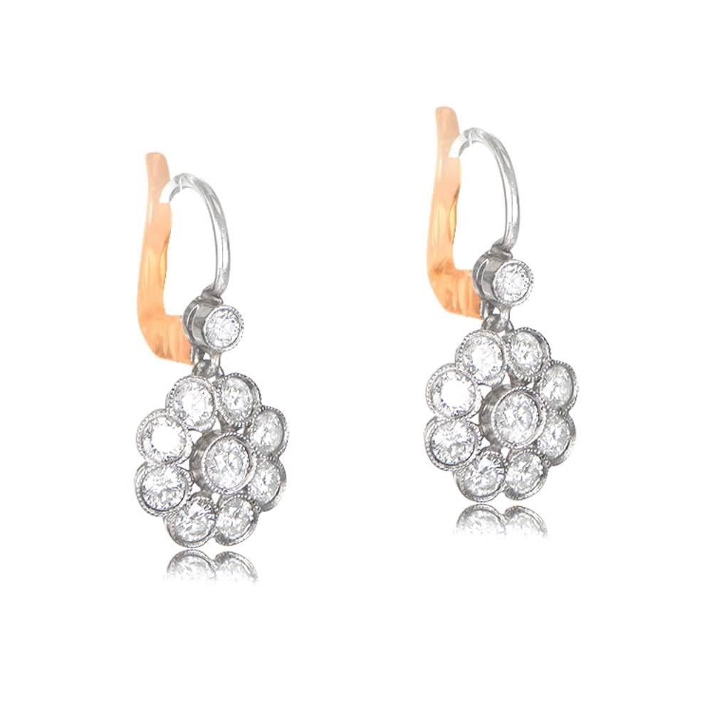 Embrace the beauty of nature with these exquisite floral motif diamond earrings. Delicately designed, they showcase a mesmerizing cluster of round cut diamonds, each one bezel set and adorned with intricate milgrain detailing. Crafted in platinum,