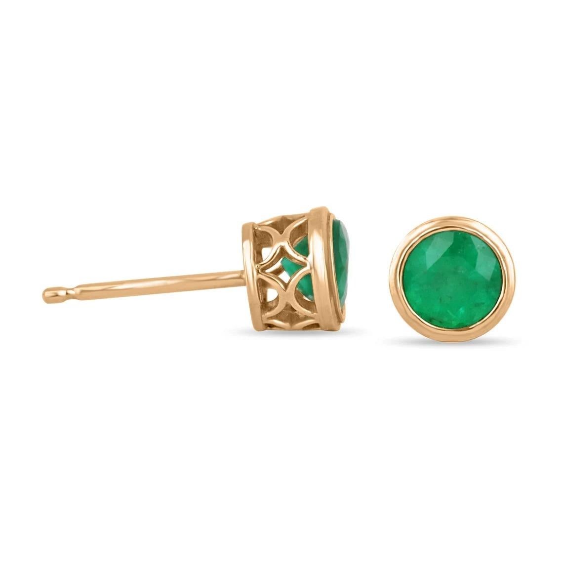 Displayed are gorgeous bezel set spring green Colombian emeralds studs in 14K rose gold. Make a stylish statement with these beauties. These 14k gold stud earrings are handmade by our expert jeweler and sparkle with an estimated total weight of 1.60