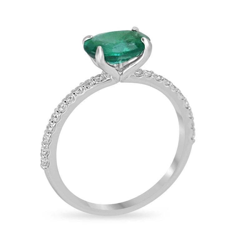 Elegance takes center stage with our Emerald and Diamond Ring. Featuring a captivating 1.30-carat oval cut emerald sourced from Zambia, this ring exudes sophistication with its medium lush green color and semi-transparent clarity. The emerald rests