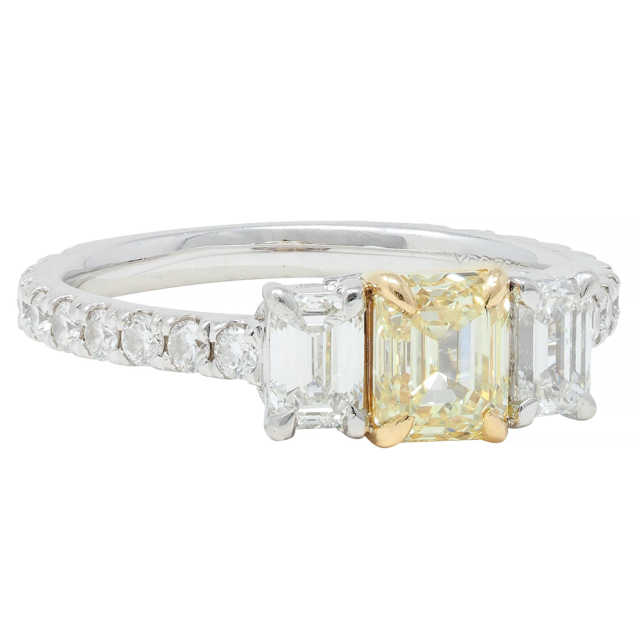 Centering an emerald cut diamond weighing 0.75 carat - fancy light yellow in color with VS2 clarity
Set in yellow gold talon prongs and flanked by two additional emerald cut diamonds
Weighing 0.48 carat total - G color with VS2 clarity and prong set