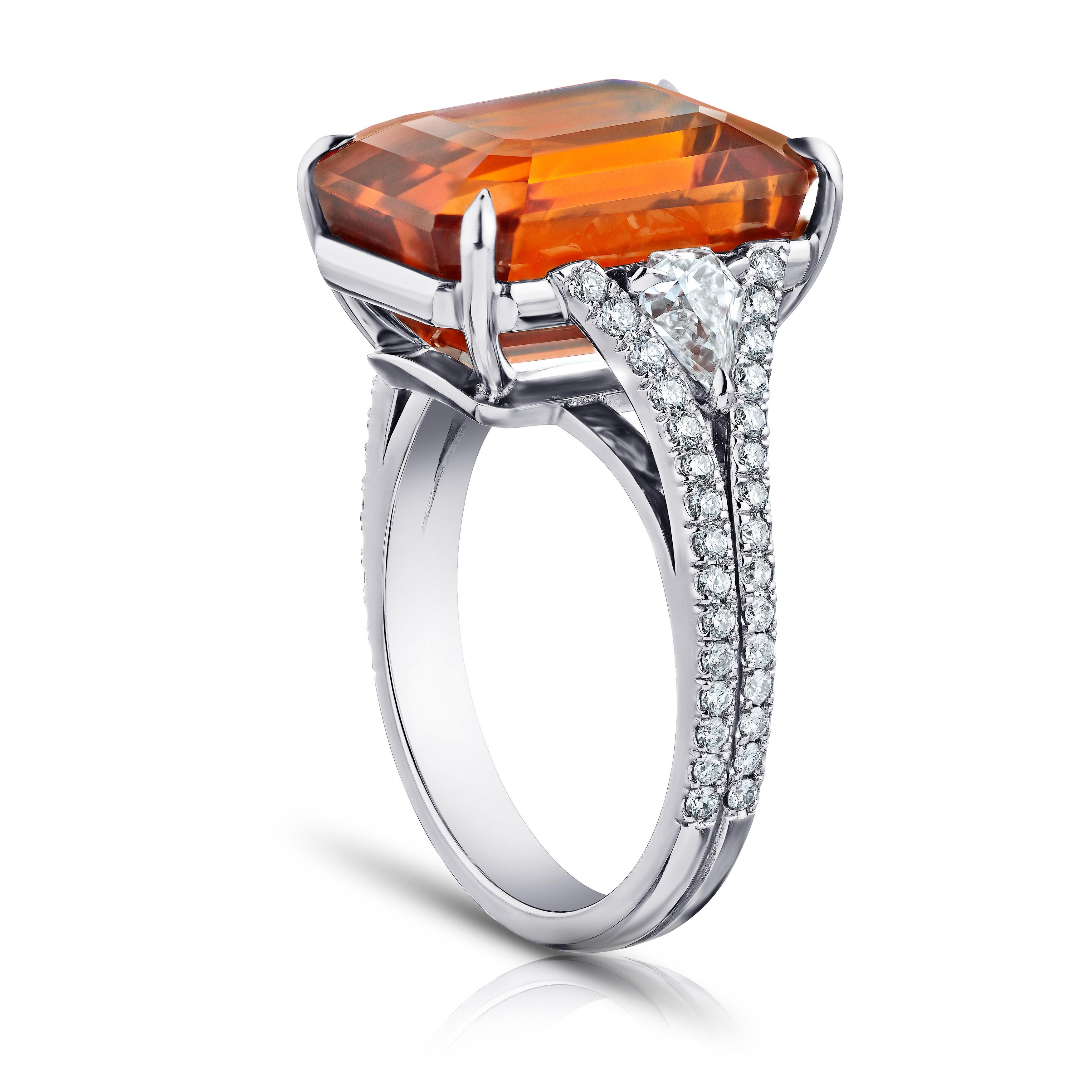 16.10 carat emerald cut orange sapphire with 2 shield shape diamonds .64 carats and 60 round diamonds .66 carats set in a platinum ring. This ring is currently a size 7.  We will resize to your finger size without charge.
