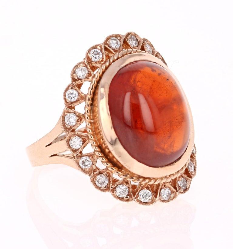 This breath taking and Victorian inspired ring has a 15.77 Carat Oval Cabochon Cut Spessartine Garnet. Spessartines are natural gemstones that belong to the Garnet family. The ring also has 20 Round Cut Diamonds that weigh 0.41 carats. The clarity