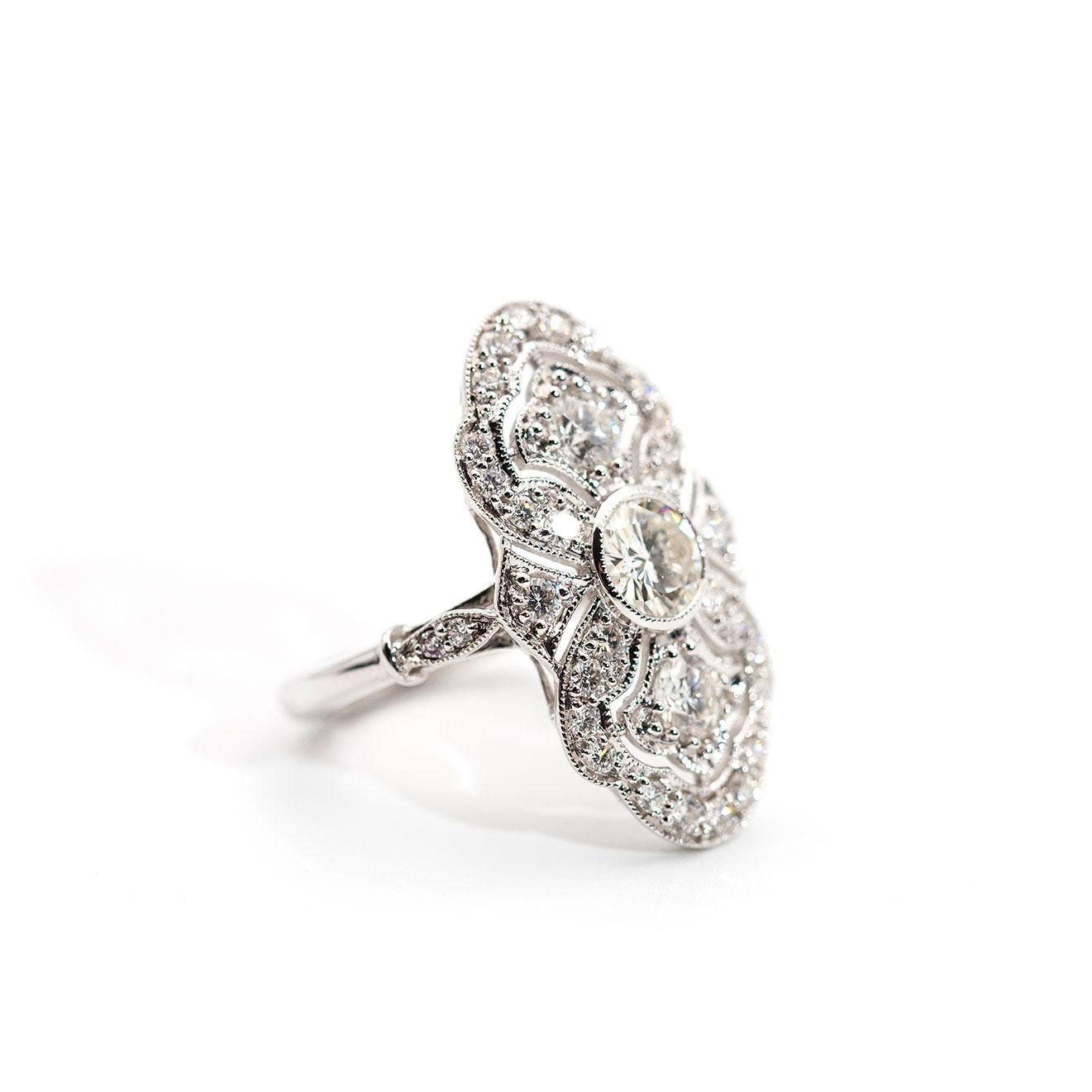 Forged in 18 carat white gold, this vintage-inspired ring features a gorgeous centrepiece certified 0.59 carat round brilliant cut diamond set in the centre of an intricately designed gallery embellished with two shimmering round brilliant diamonds