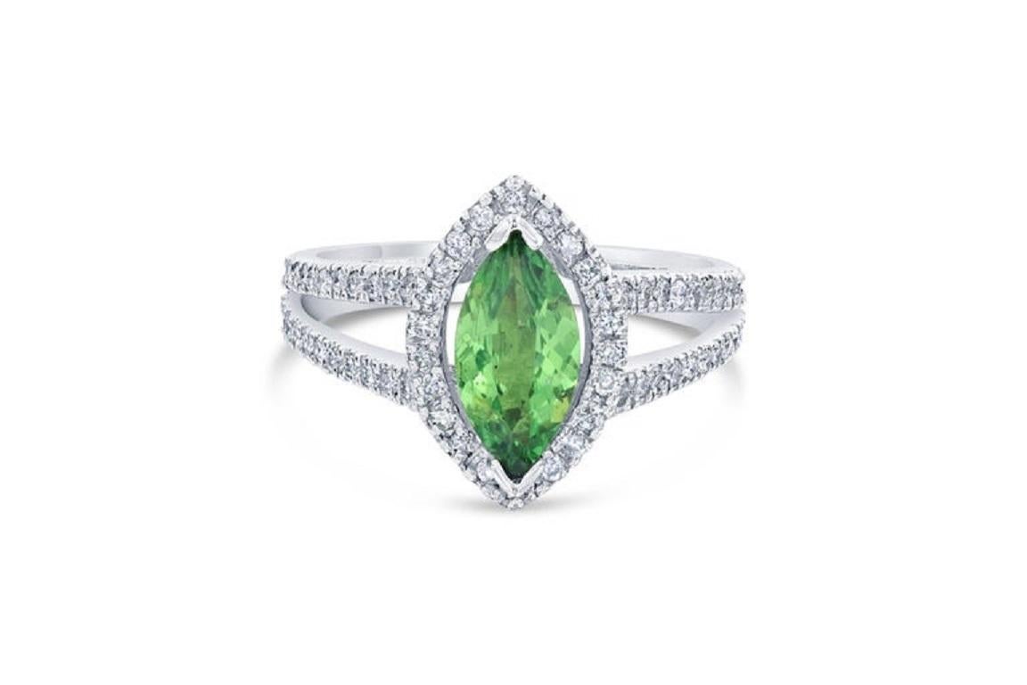 This ring has a natural Marquise Cut Tsavorite Garnet which weighs 1.10 carats and is surrounded by 70 Round Cut Diamonds that weighs 0.52 carats. The total carat weight of the ring is 1.62 carats. 
The ring is made in 14K White Gold and weighs