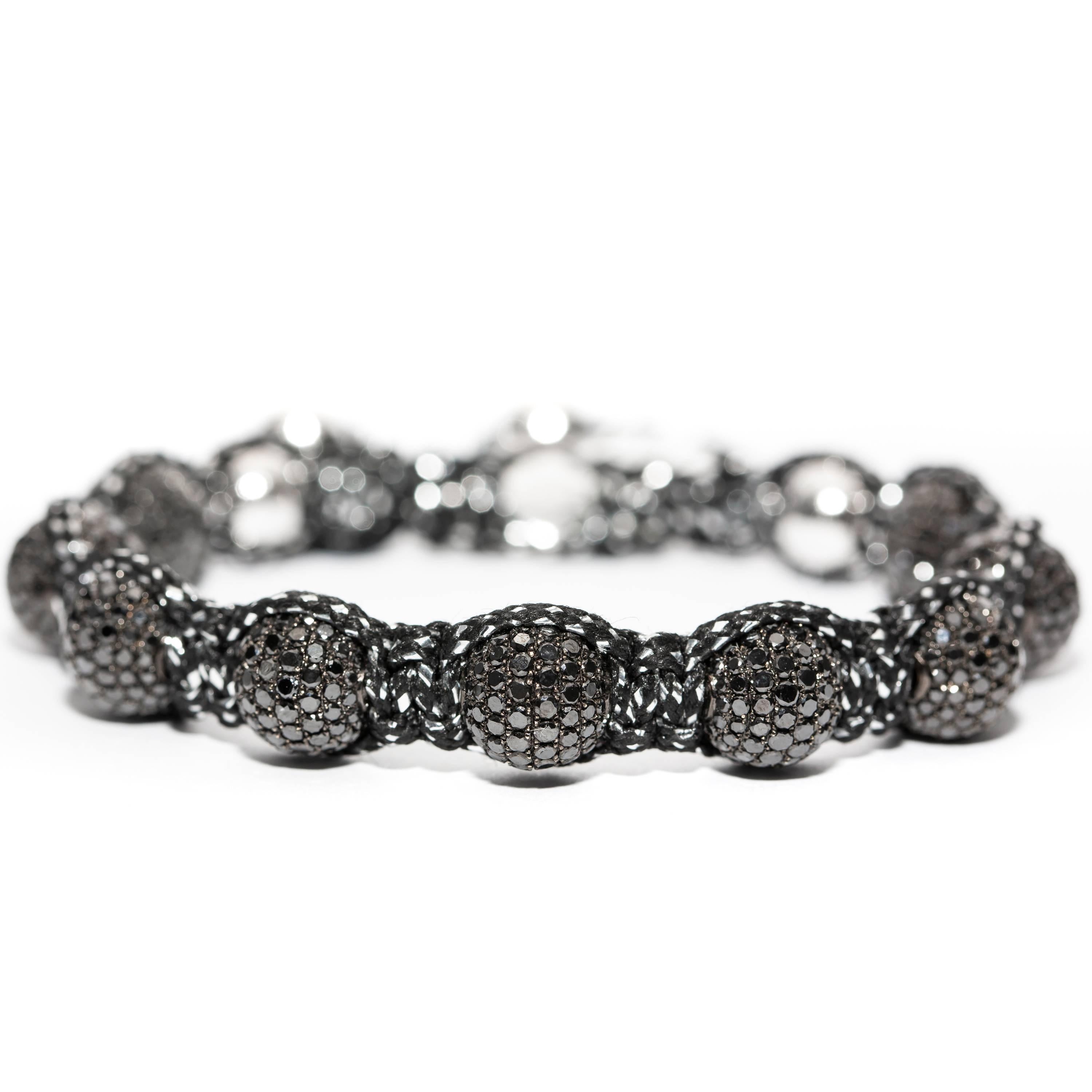 A Stylish 16.20 Karat Pave set natural Black Diamond ball bracelet strung on Black and Silver cord featuring a Silver Tresor Paris Logo This striking bracelet is abundant with Diamonds that gently shimmer in the light, a truly alluring fashion