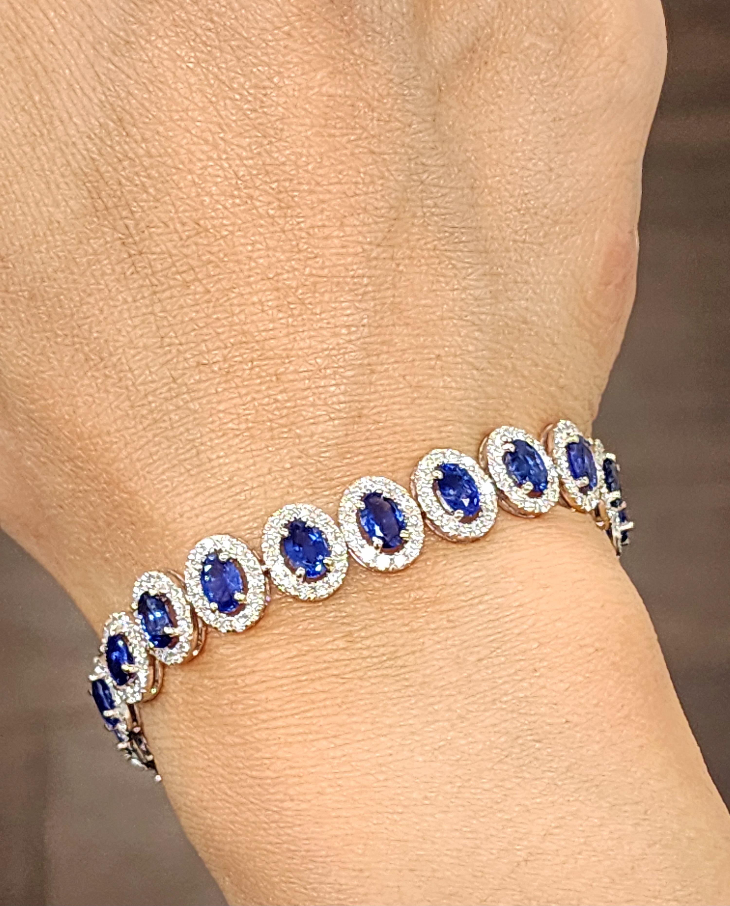 This stunning bracelet features 12.40 carats of oval blue Ceylon sapphires set in platinum. It is accented with 3.89 carats of round white diamonds, graded E color and VS1 clarity. This modern piece was crafted in the United States by skilled