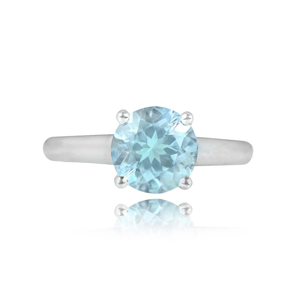 Elegant solitaire ring crafted in 18k white gold, showcasing a 1.62-carat round natural aquamarine. The under gallery is adorned with round brilliant-cut diamonds, adding a touch of sparkle. The total approximate diamond weight for the accent