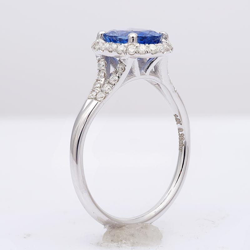 Dieser exquisite Ring zeigt einen natürlichen, kühlen blauen Saphir in einer Fassung aus 14 Karat Weißgold, der von Diamanten umgeben ist und die Illusion einer zarten Blume erzeugt. Die auffallend blaue Farbe des Saphirs zieht die Blicke auf sich,