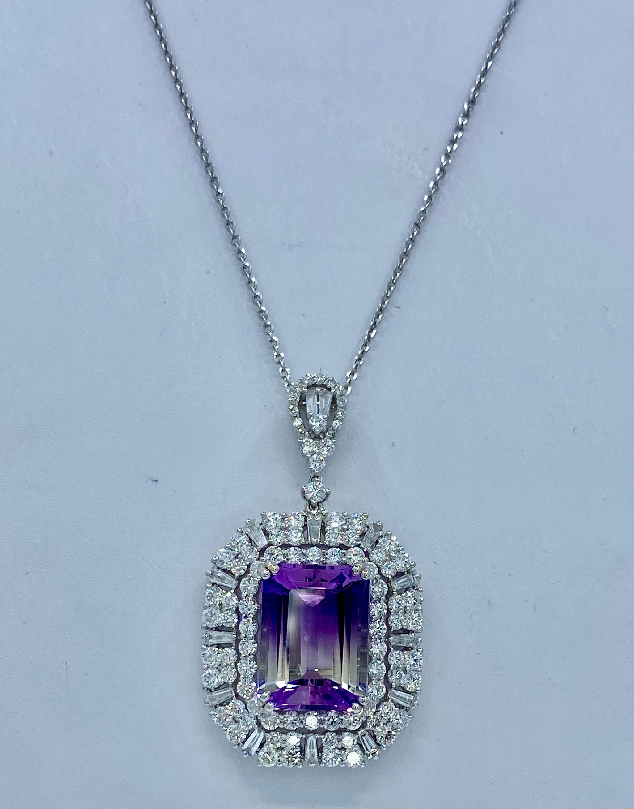 A stunning and large, emerald cut, chiaroscurro effect bi-color amethyst is talon prong set in 18 karat white gold and surrounded by a mesmerizing octagonal halo of round brilliant diamonds and then further surrounded by another octagonal halo of